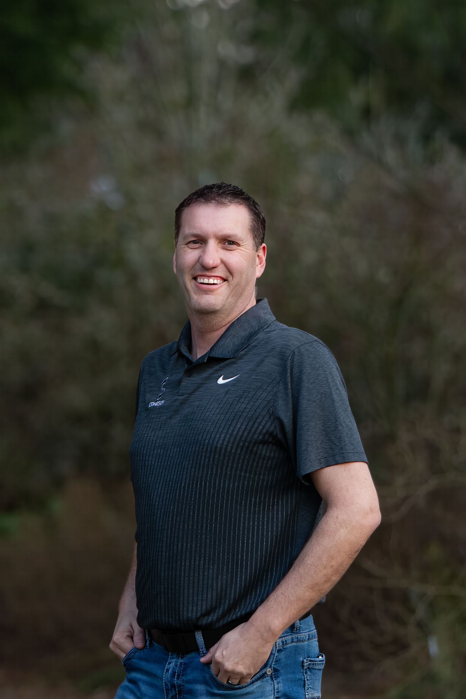 Casual outdoor headshot session wearing dark polo shirt against natural background in Maple Valley, WA