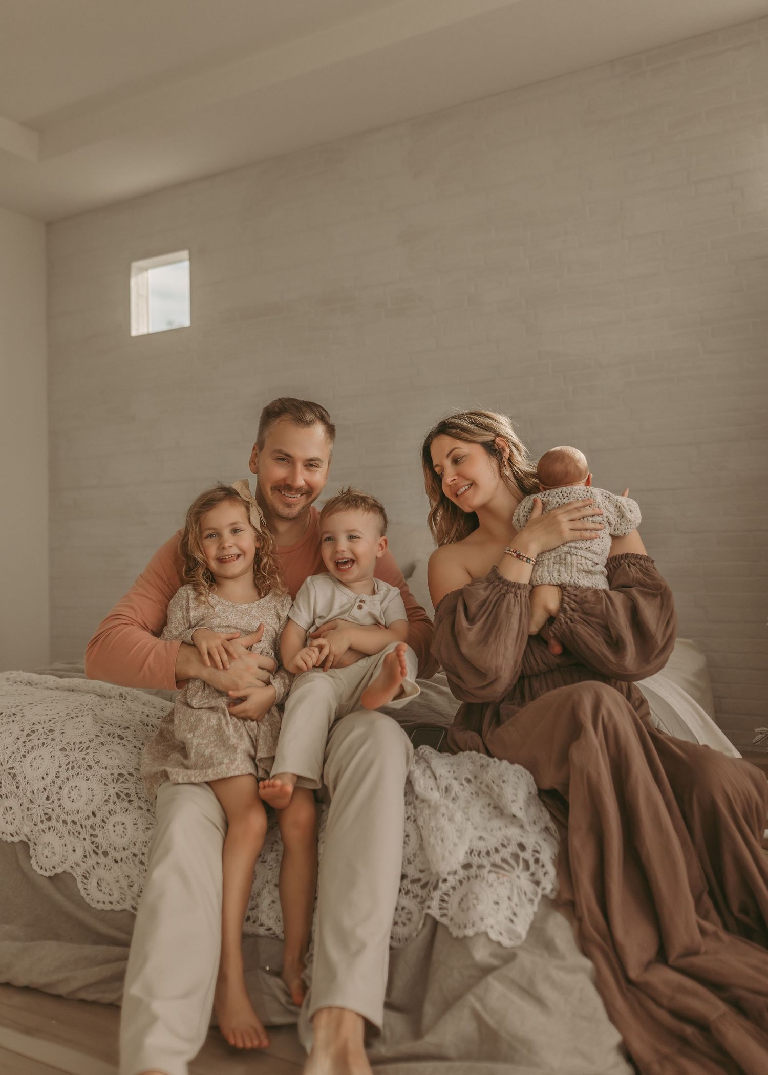 Family lifestyle photos in neutral tones showing intimate moments on a cozy couch.