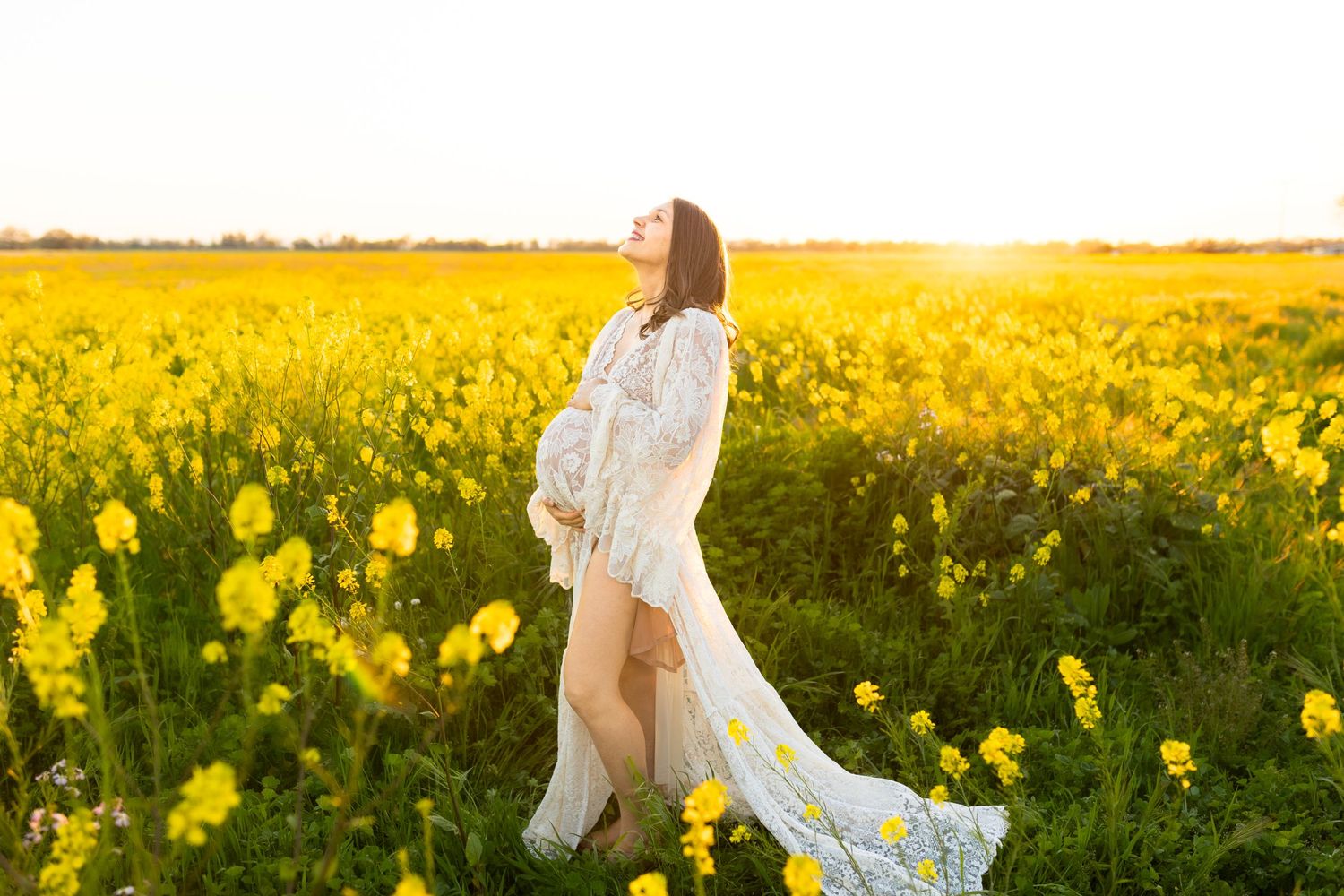 Ethereal sunlit field of bright yellow daffodils with figures walking through the flowers.