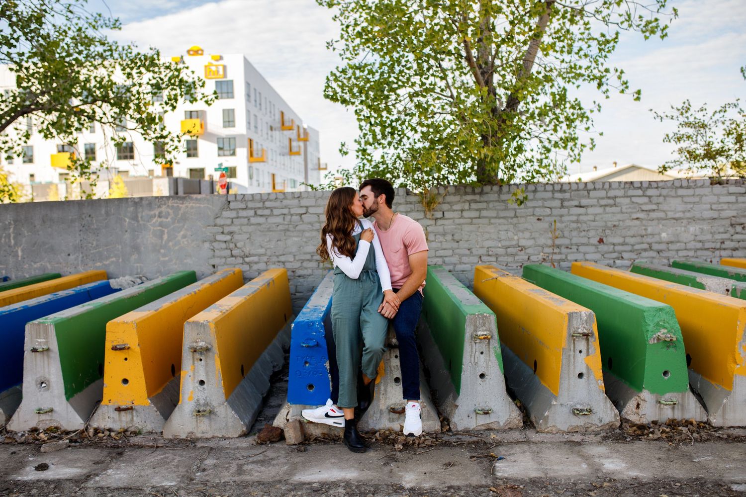 Colorful outdoor seating area with yellow and green benches against a brick wall.