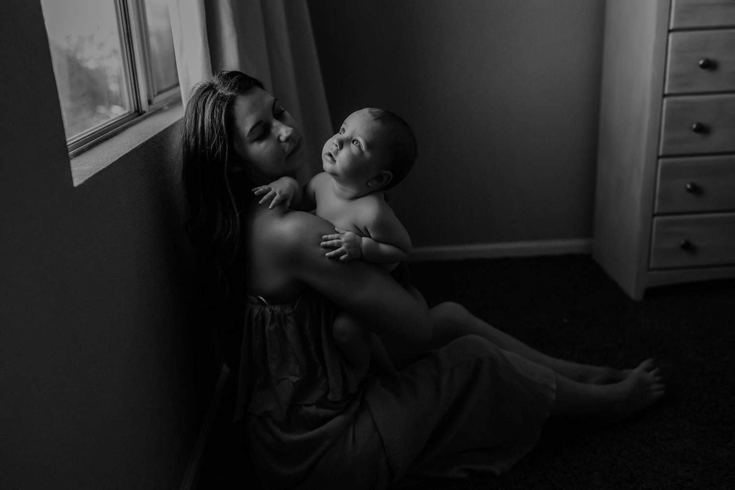 Moody black and white portraits taken near a window with dramatic lighting.