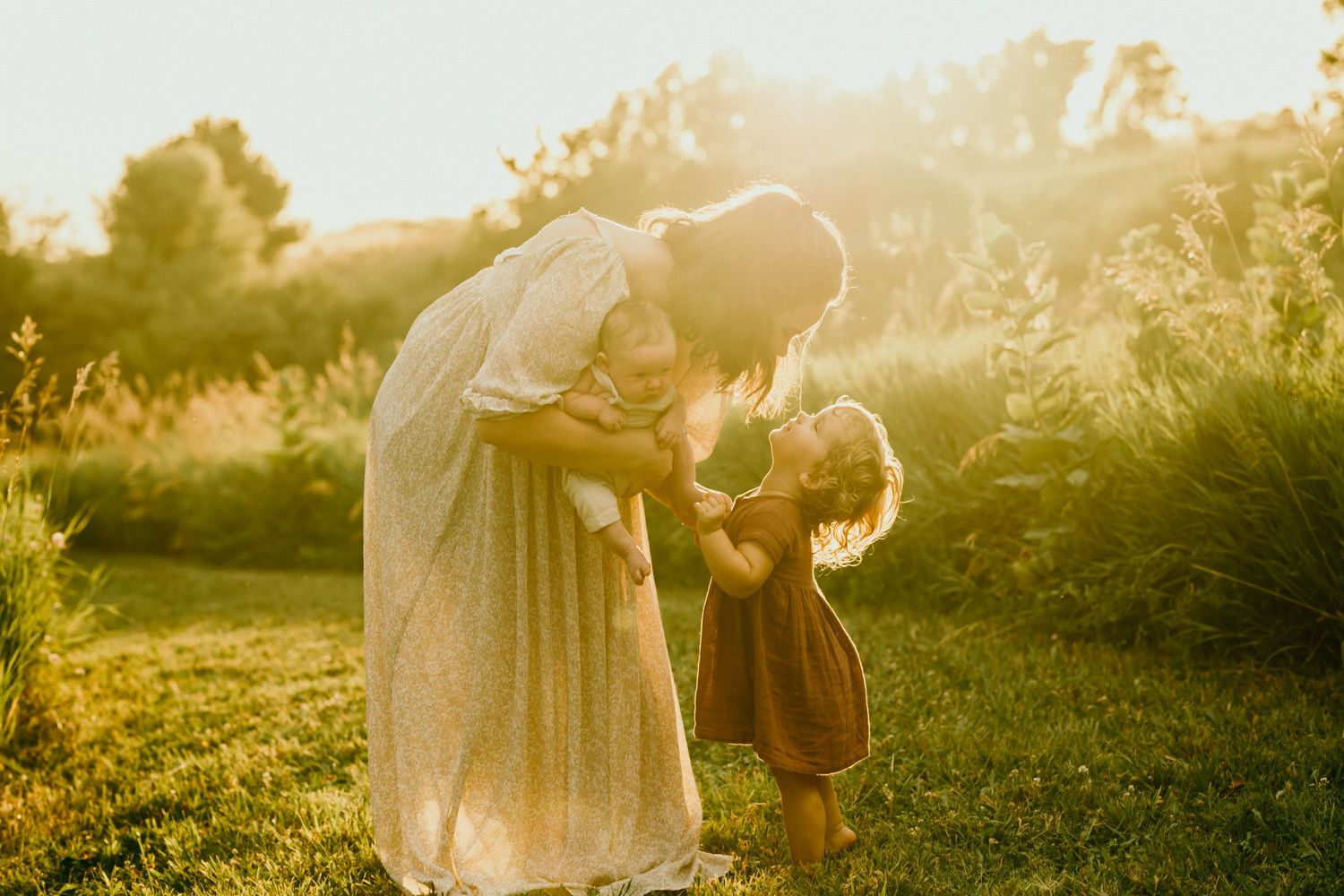 Candid family moments captured during sunset in a dreamy outdoor setting.