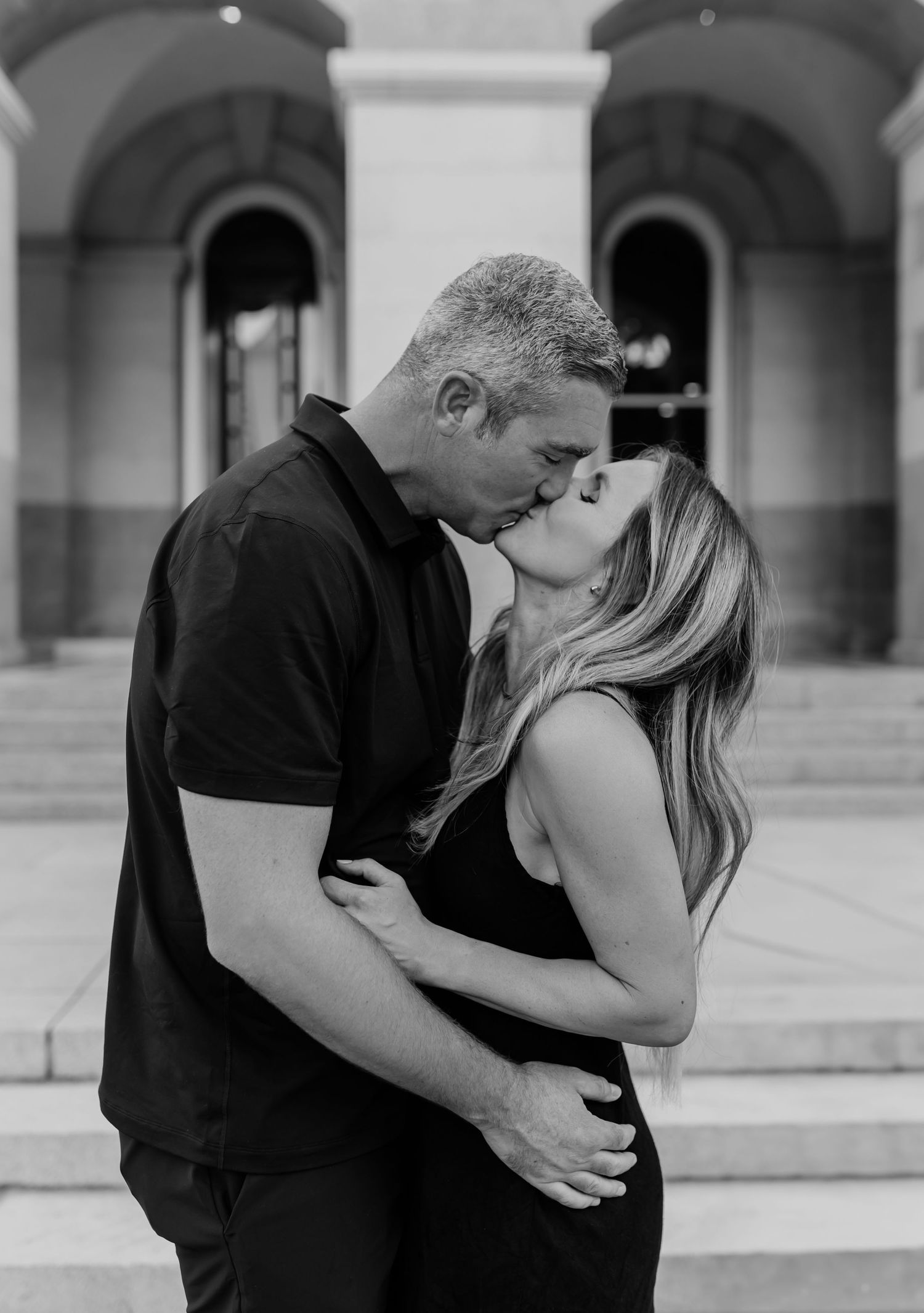 Black and white portraits showing tender embraces between family members in an outdoor courtyard setting.