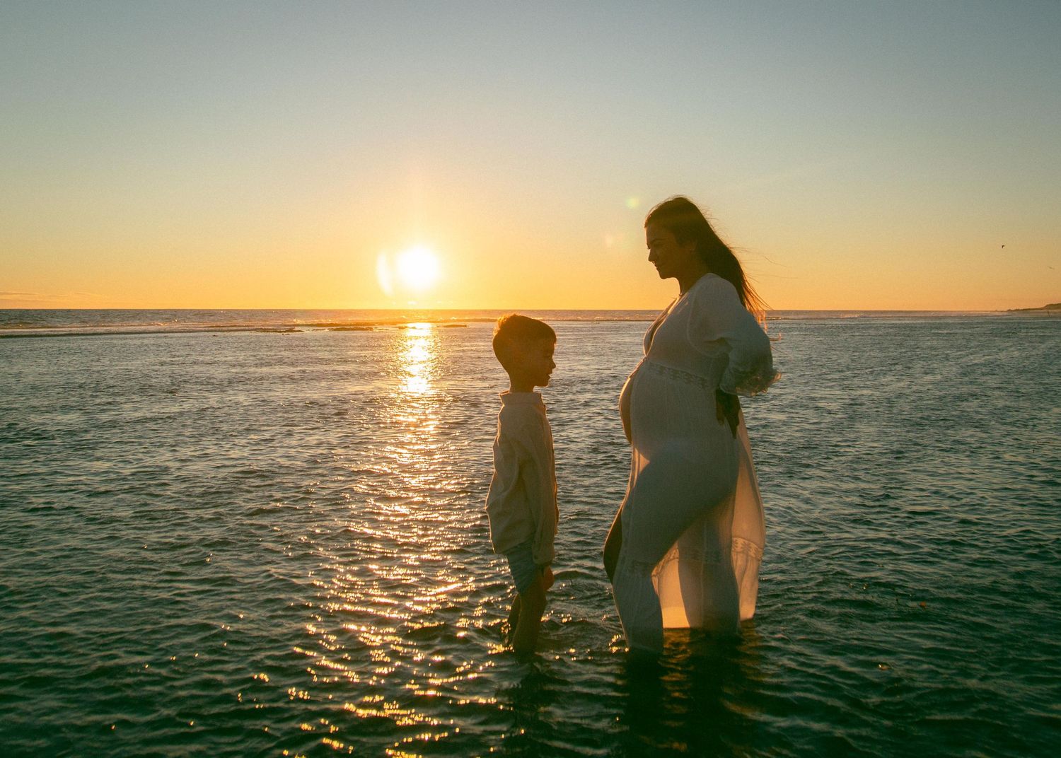 A pregnant woman and her son at sunset at Yanchep Lagoon