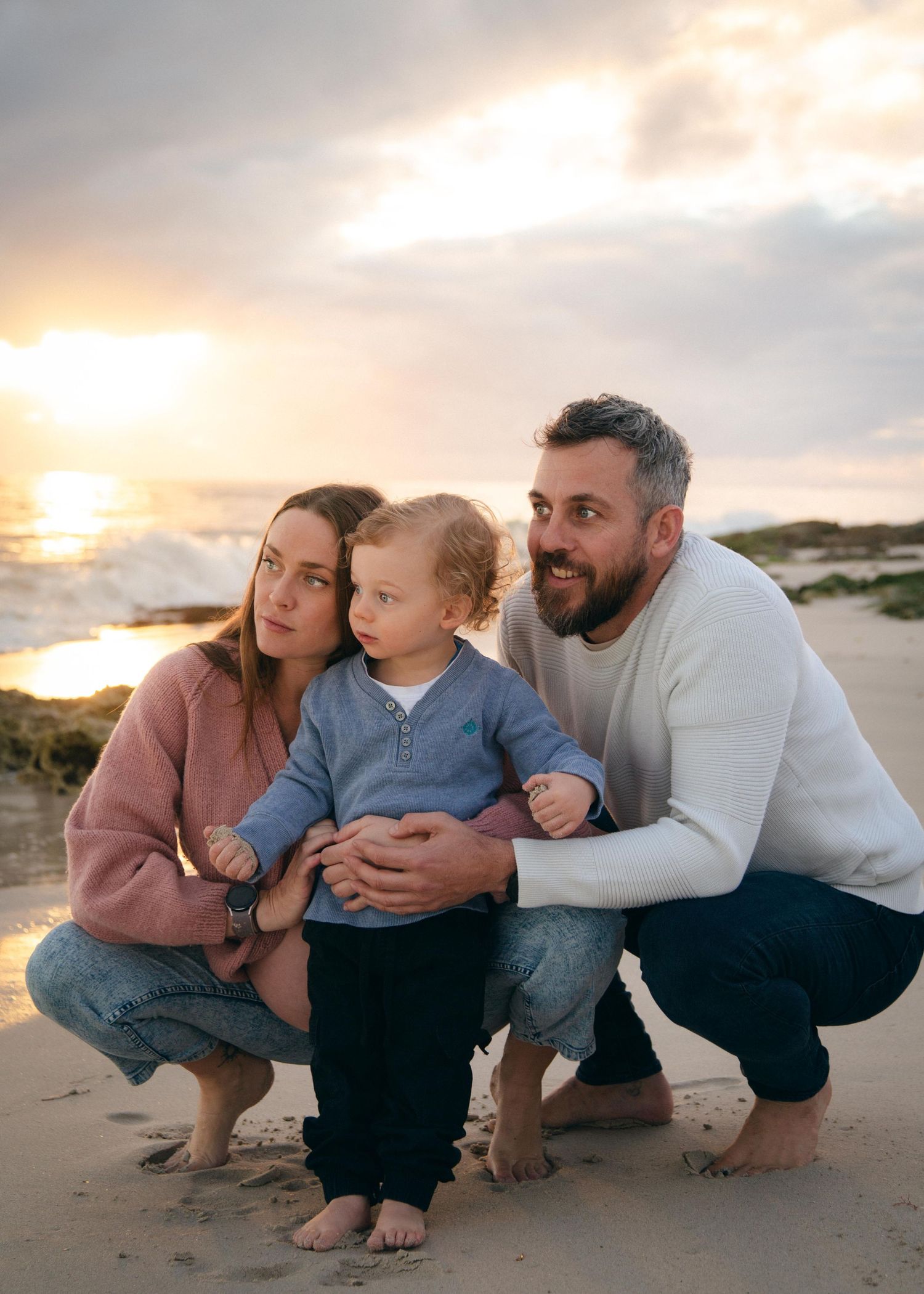 A toddler and his family at Quins Beach, WA at sunset