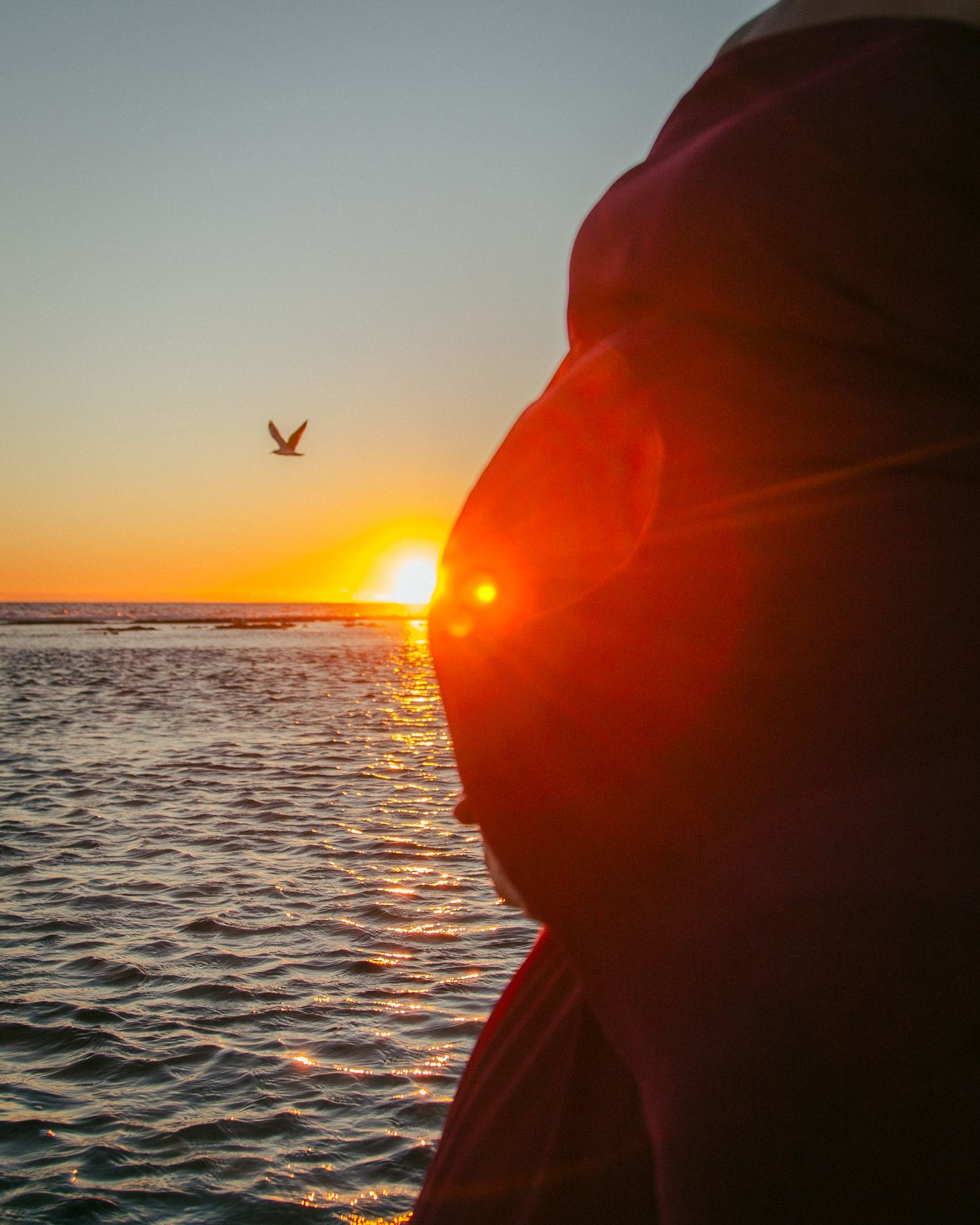 Maternity photo showing only the pregnant belly with the sunsetting behind.
