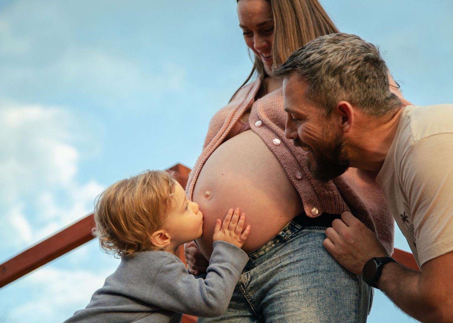 A Toddler kissing his mothers pregnant belly at Quinns Rocks