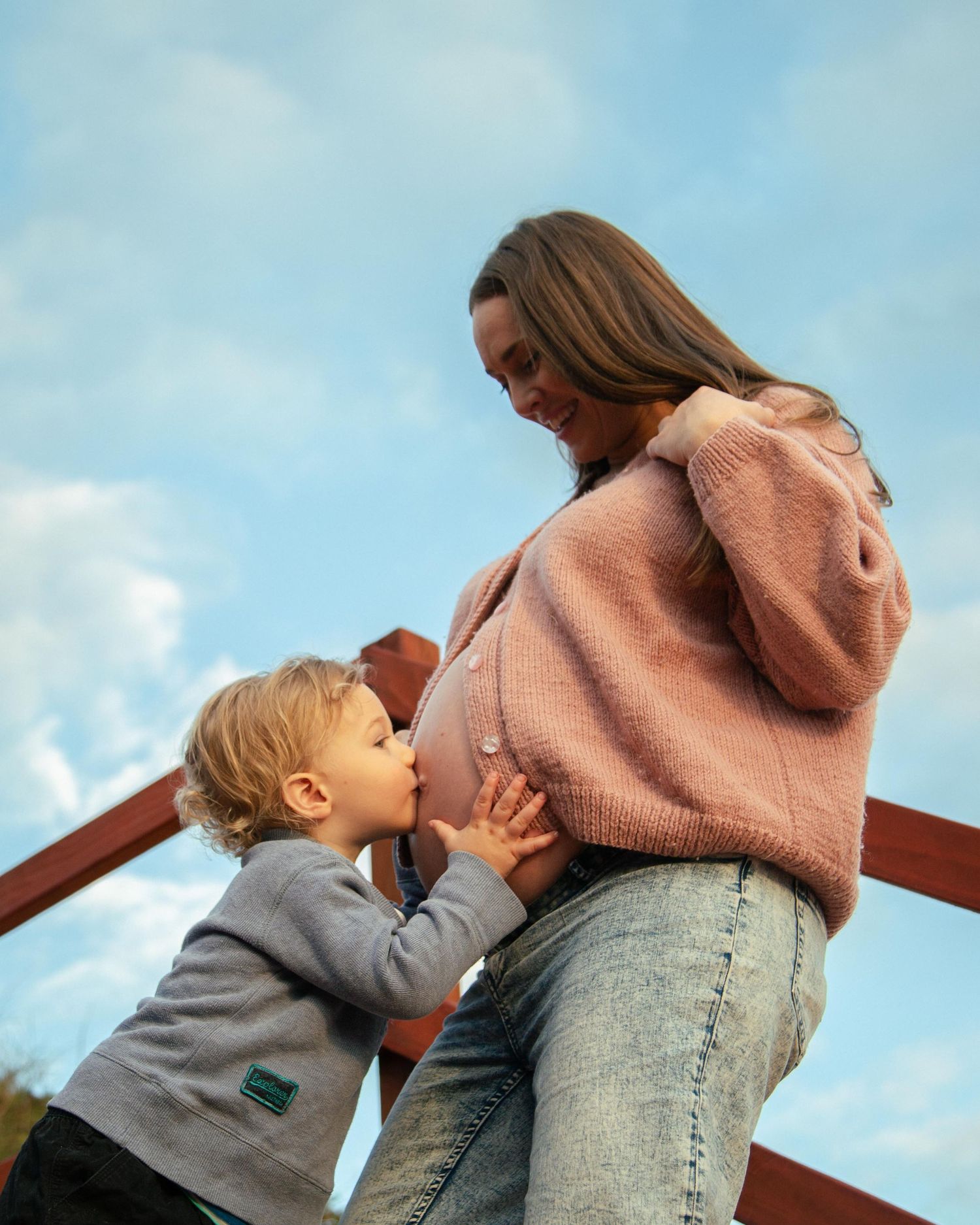 A Toddler kissing his mothers pregnant belly at Quinns Rocks