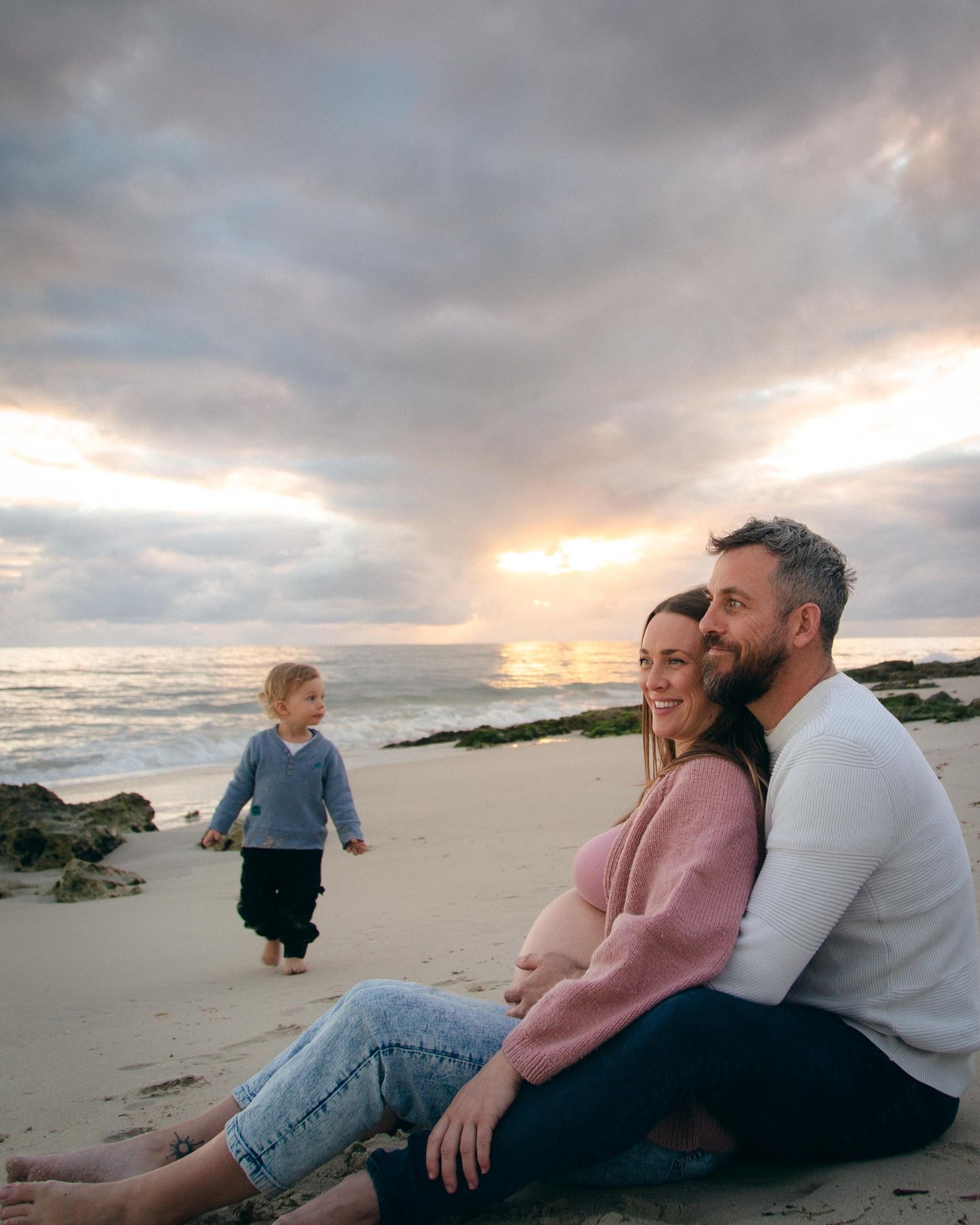 A toddler and his family at Quins Beach, WA at sunset