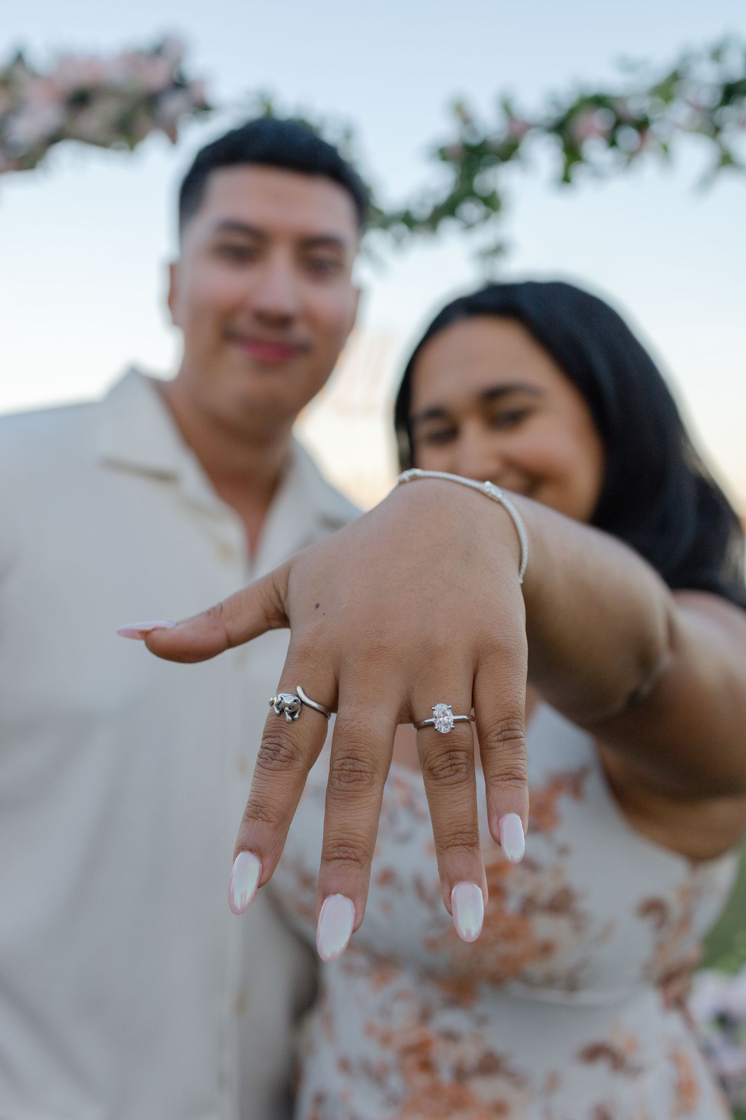 Close-up sequence of hands showing off engagement rings in multiple romantic poses against a blurred background.