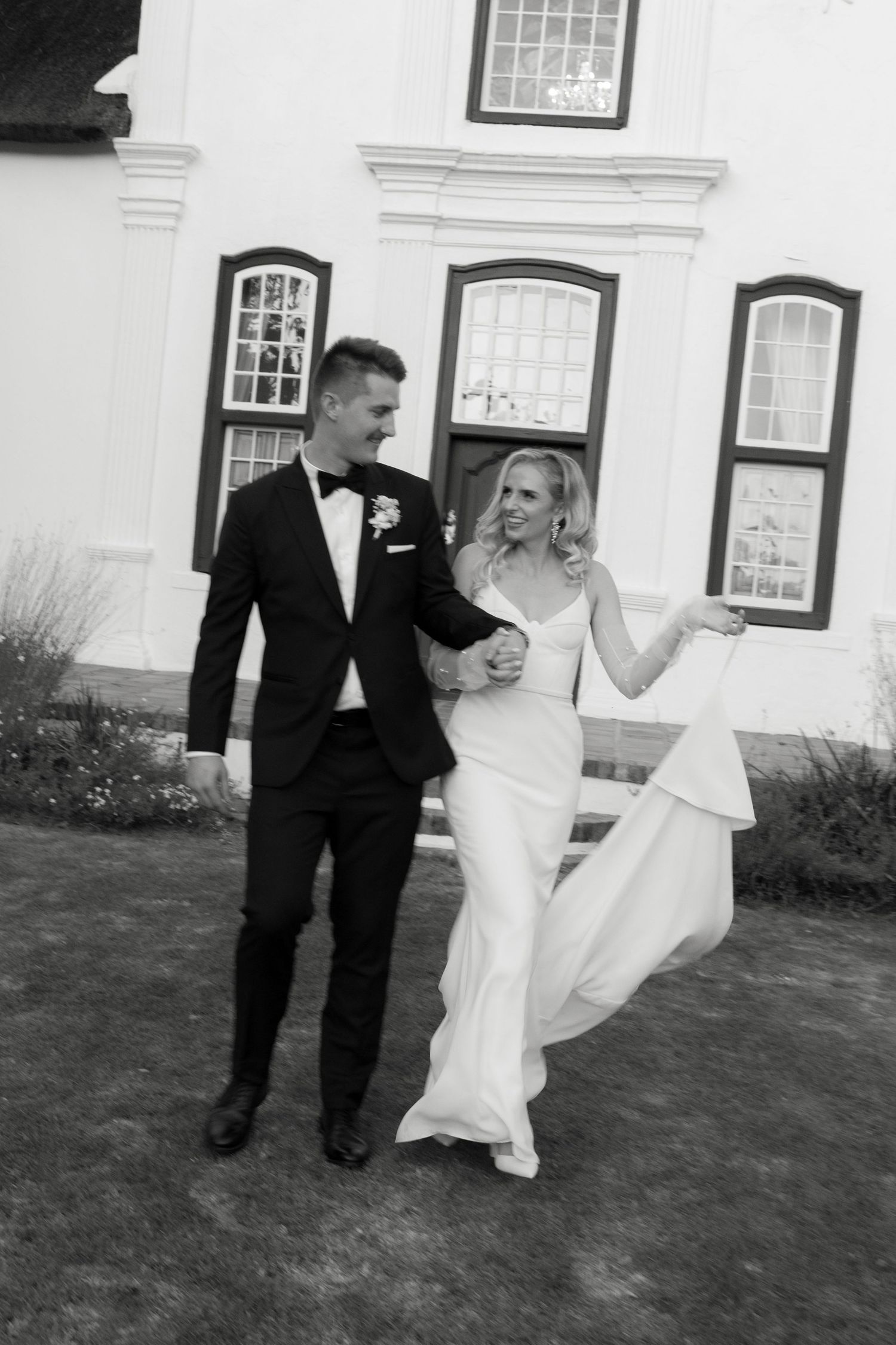 Classic black and white wedding portrait in front of a historic white building.