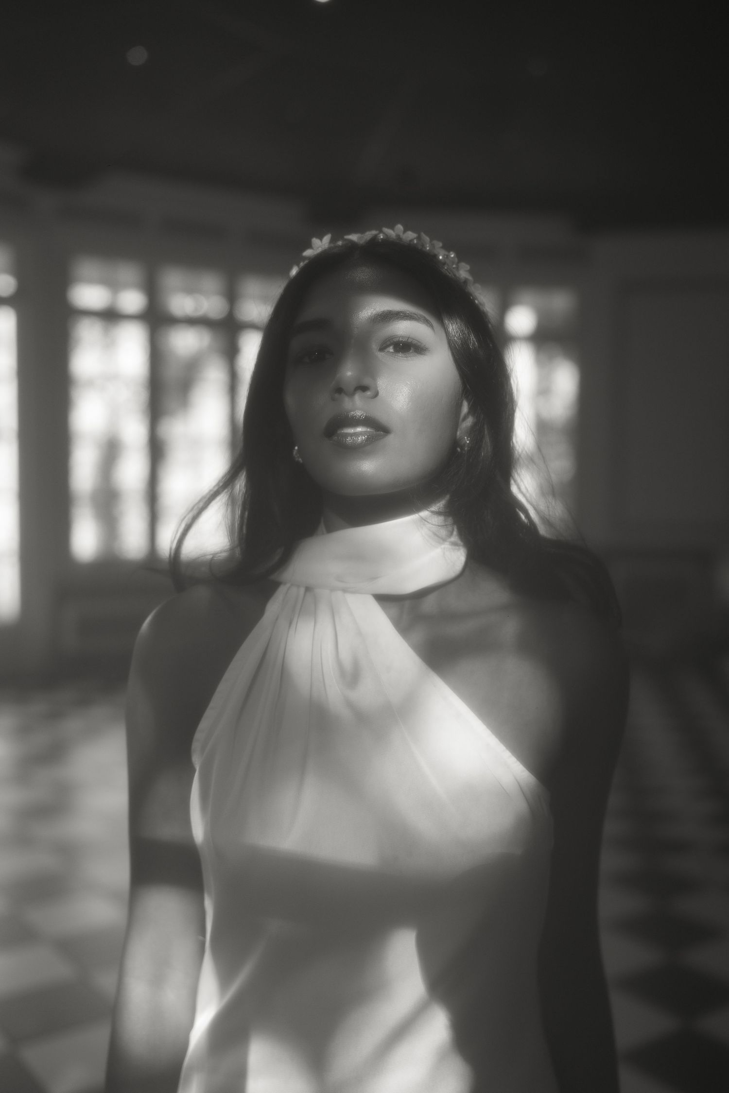 Dramatic black and white portrait with soft lighting and halter neckline.