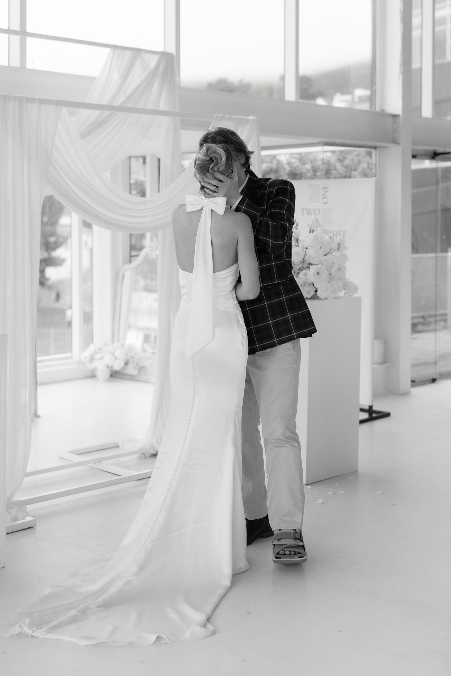 A wedding dress fitting session showing final adjustments being made to a flowing white gown.