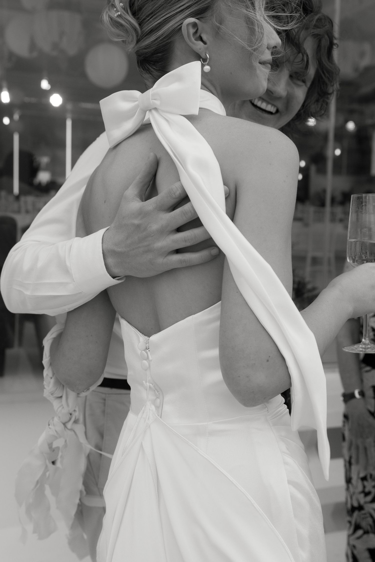 An intimate black and white photo capturing a tender embrace during a wedding celebration.