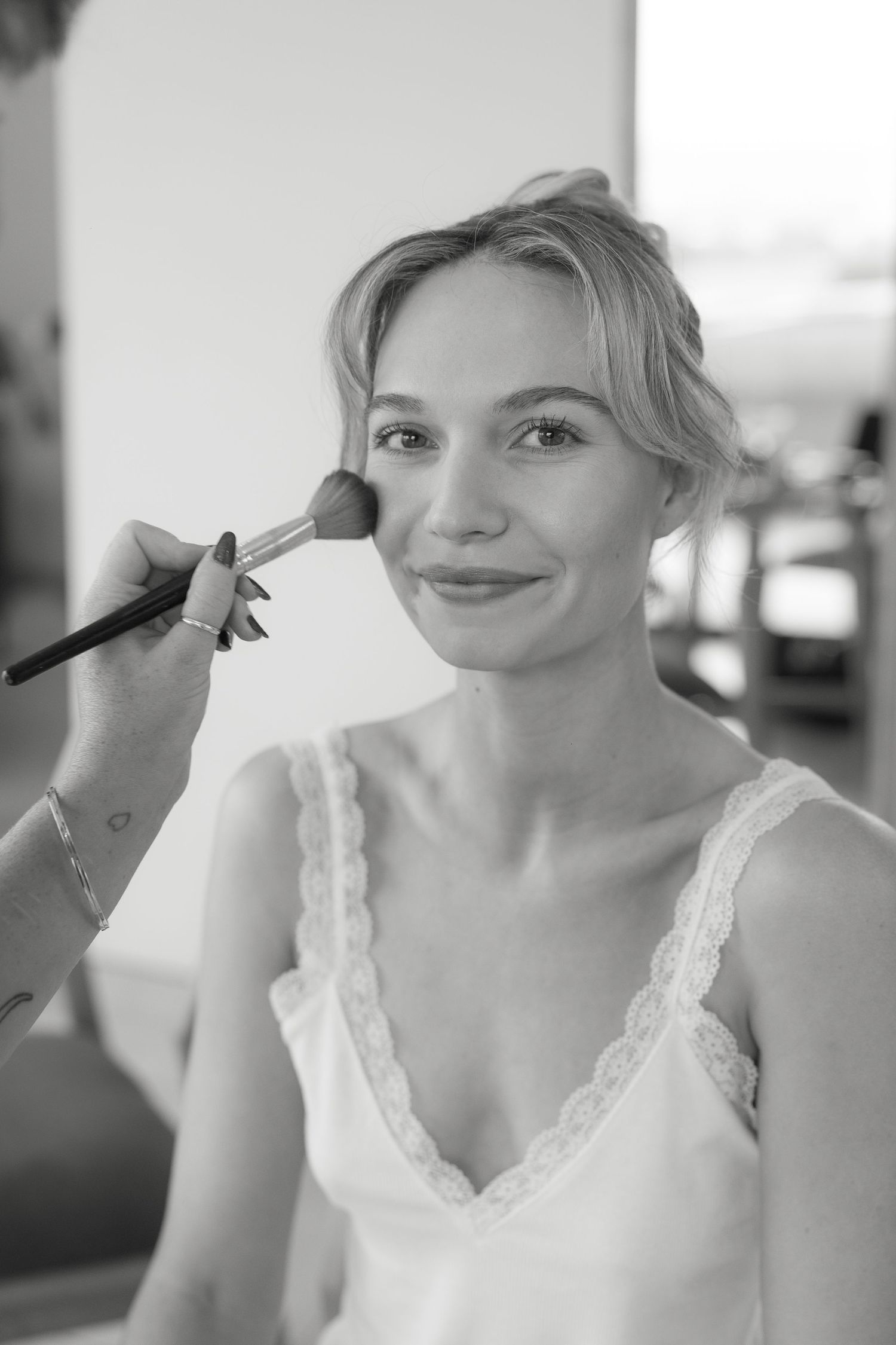 Behind the scenes makeup application in black and white.