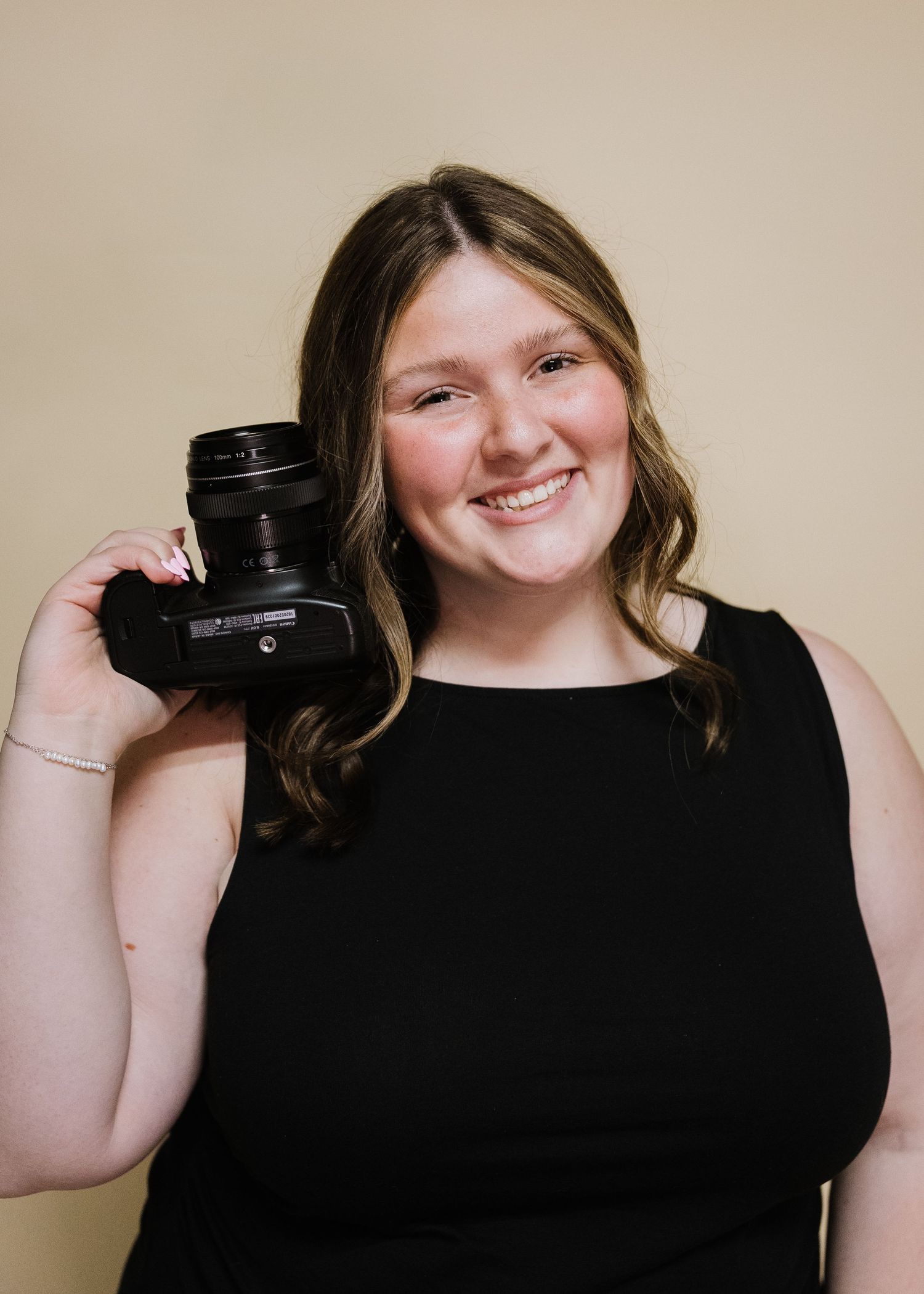 A series of four similar photos showing someone in a black shirt holding up a camera lens against a beige wall.