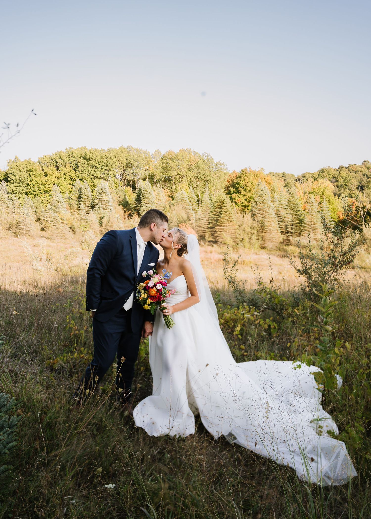 A romantic wedding couple shares intimate moments in a golden meadow during sunset in a series of connected photos.