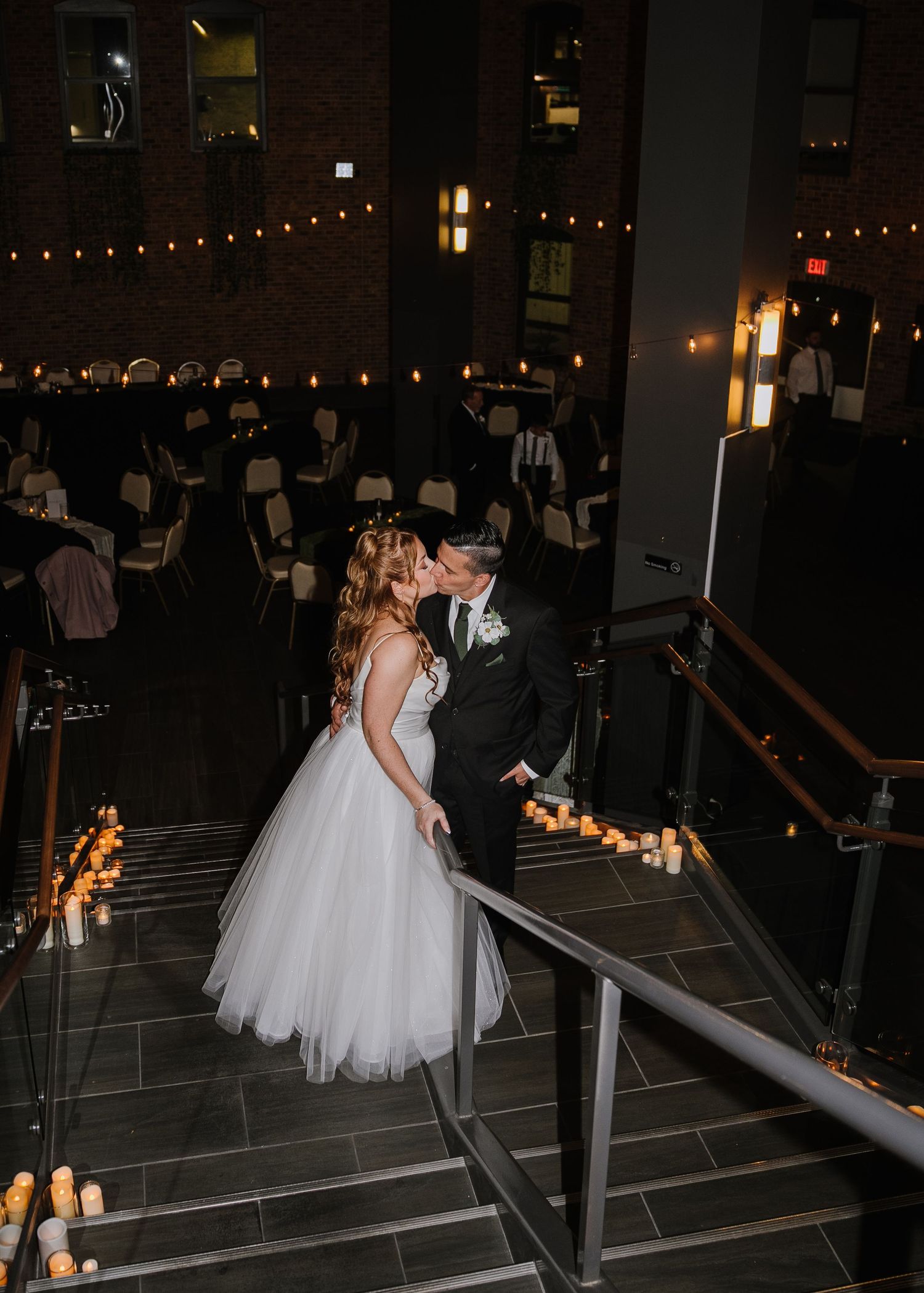 Romantic candlelit staircase decorated with glowing lanterns creates an intimate atmosphere at an evening wedding reception.