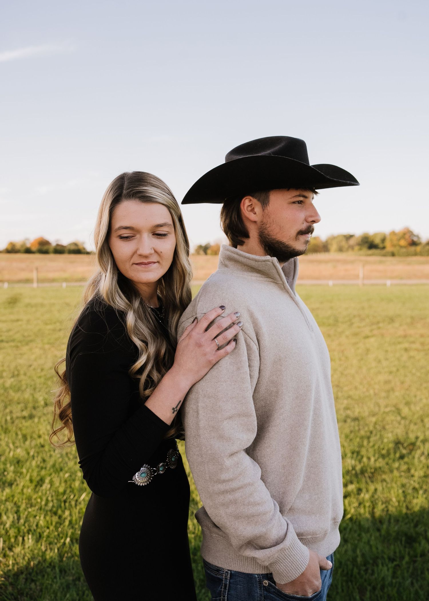 A couple in western attire shares tender moments across four progressive photos in a sunny field.