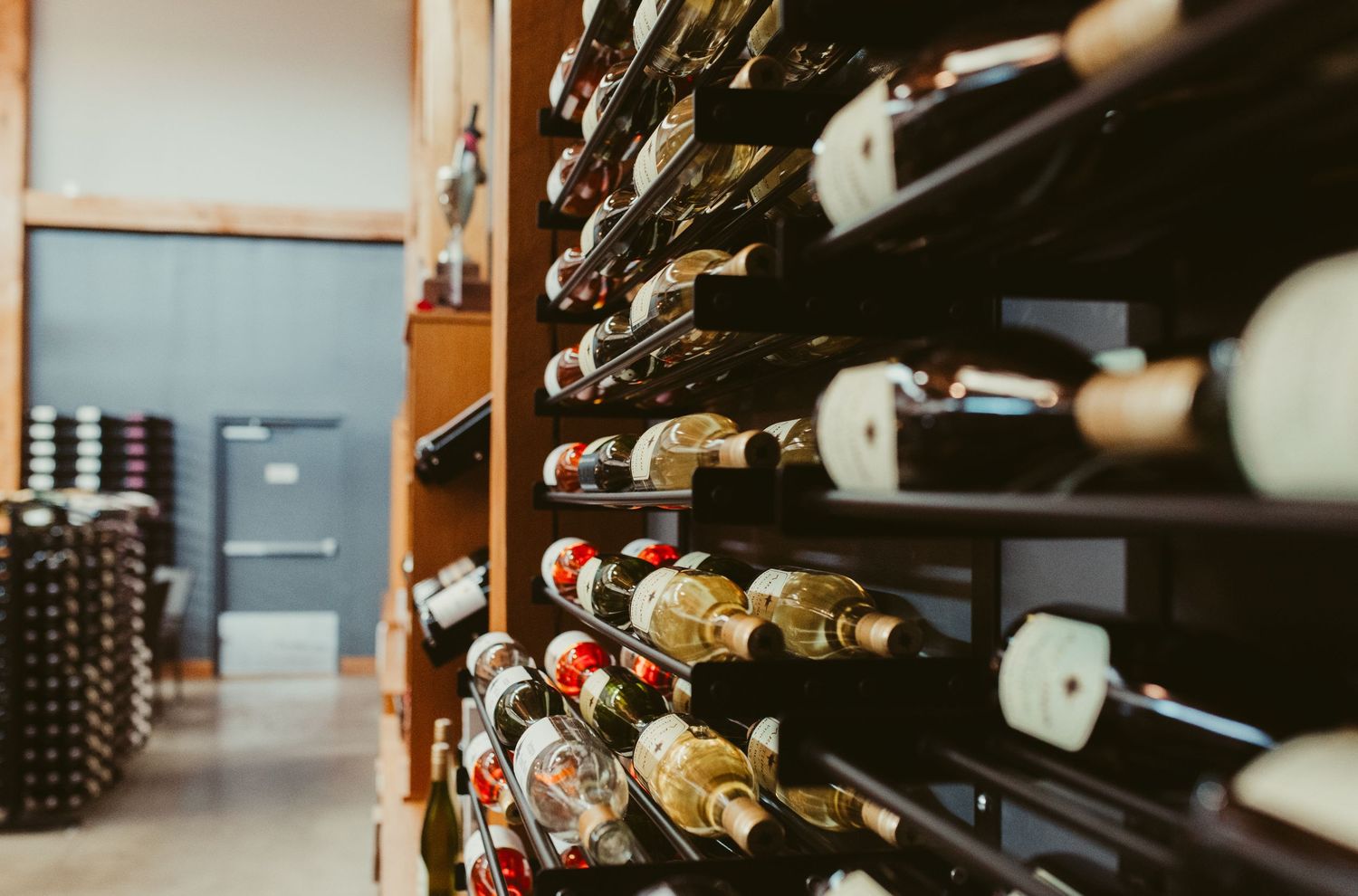 Wine bottles stored in wooden racks at a restaurant cellar with selective focus on vintage labels.