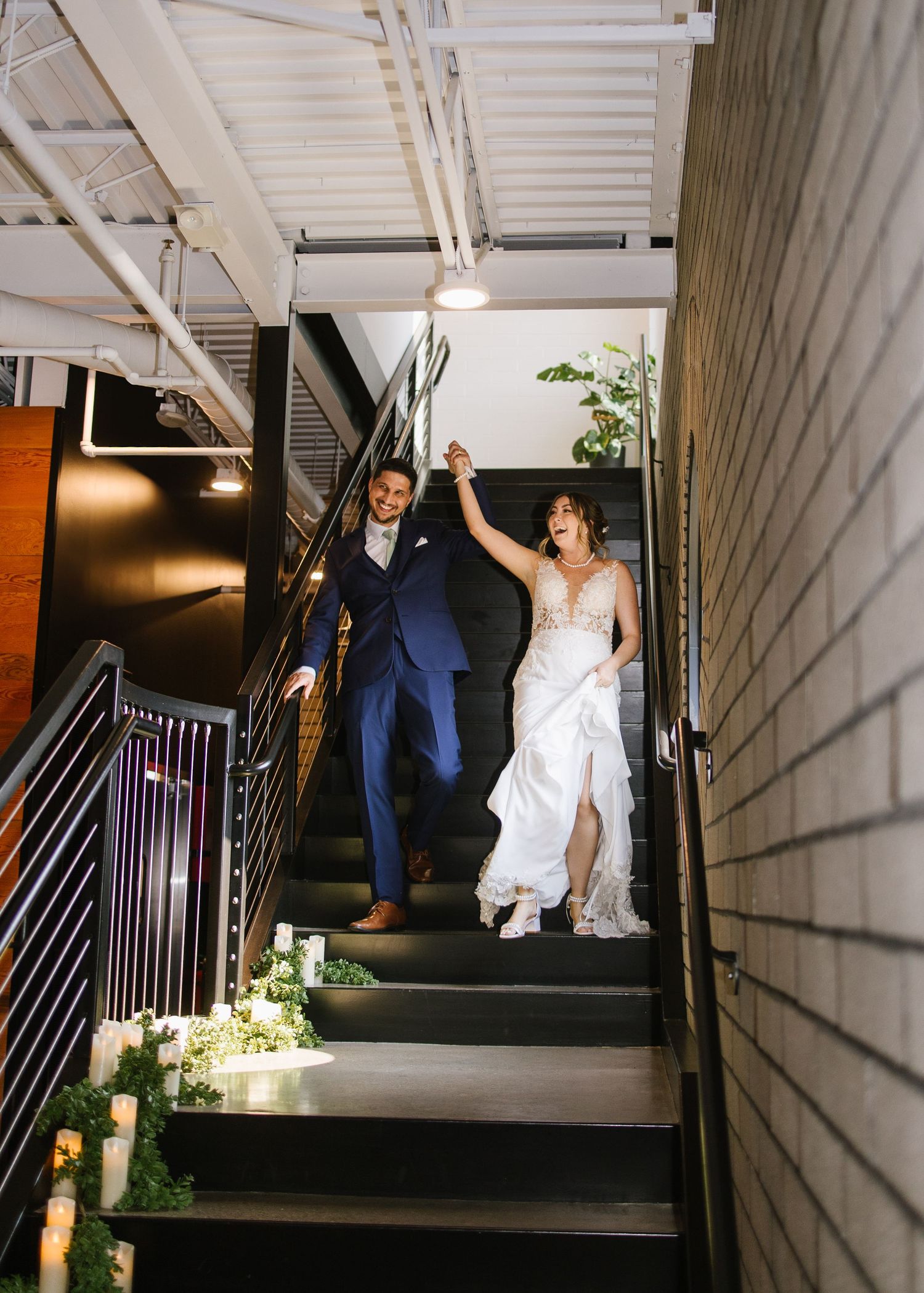 Wedding couple ascends dark staircase decorated with romantic candle lighting and greenery in sequential photos.