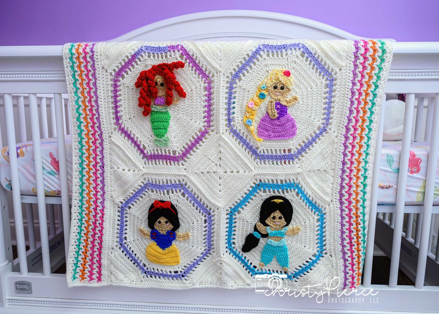 Handmade baby blanket featuring four octagonal panels with colorful princess-themed crochet designs and rainbow striped border.