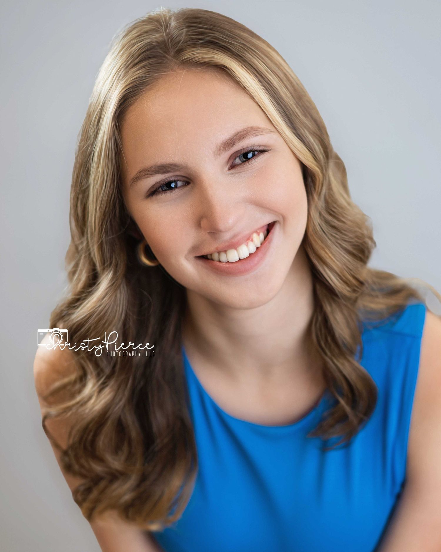 A series of five studio portraits showing a person in a bright blue sleeveless top with wavy hair against a light background.