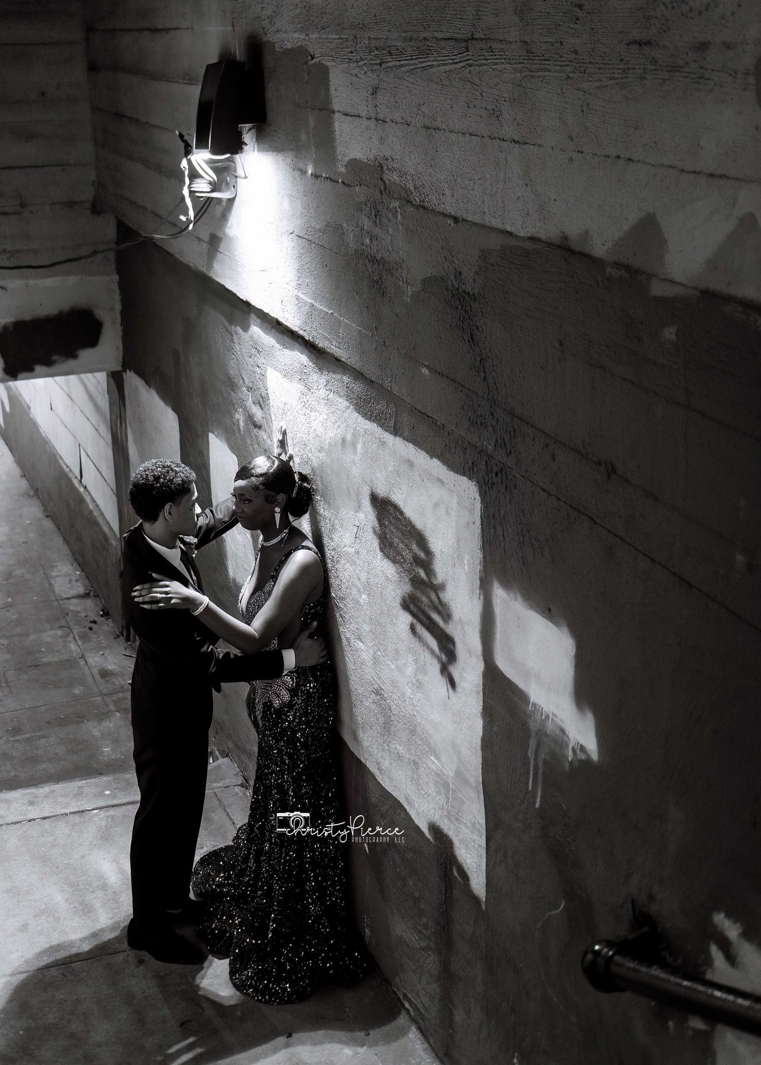 A romantic black and white sequence shows a couple dancing and embracing against a textured concrete wall.
