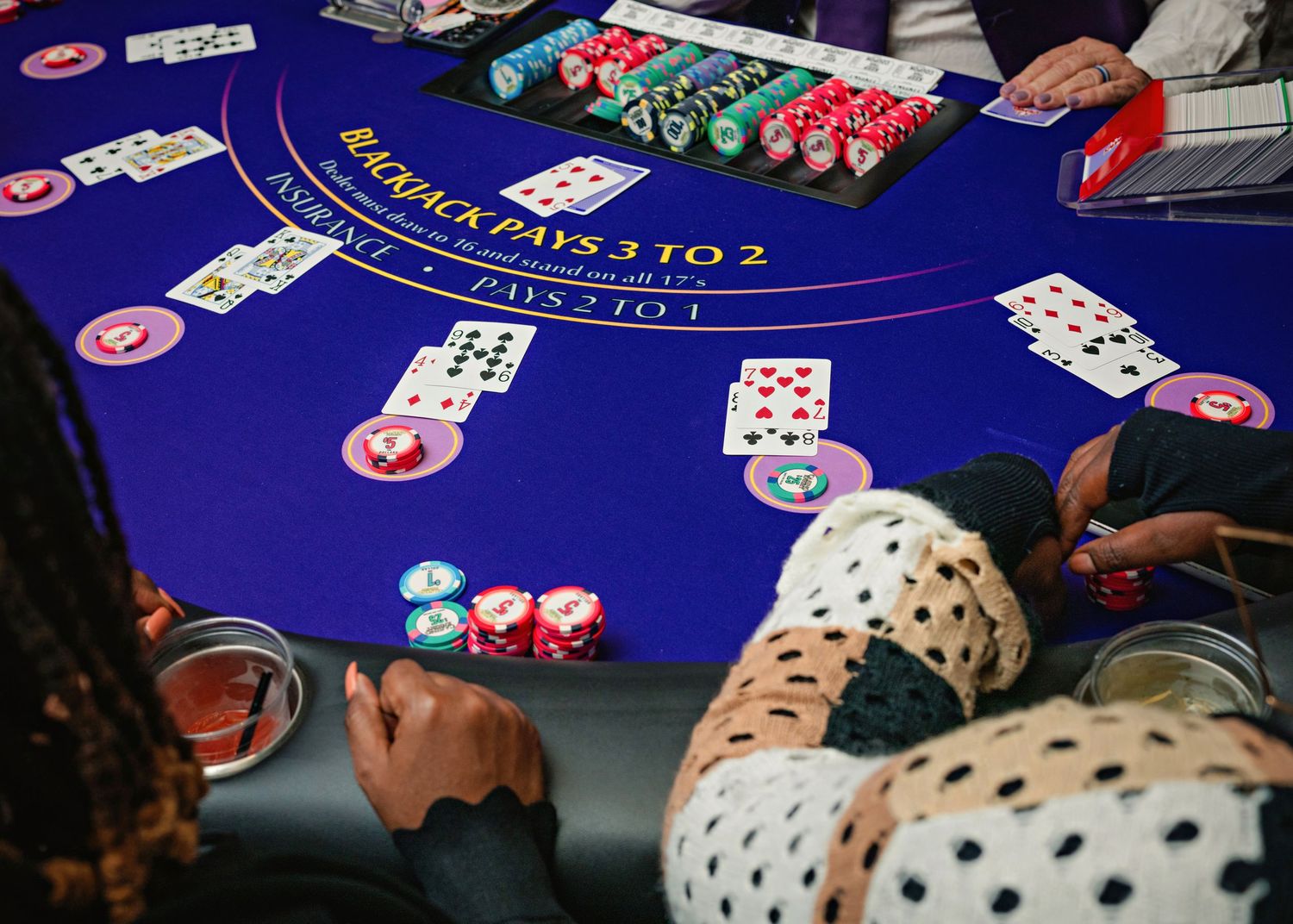 A series of connected photos showing a blue blackjack table with playing cards and casino chips during gameplay.