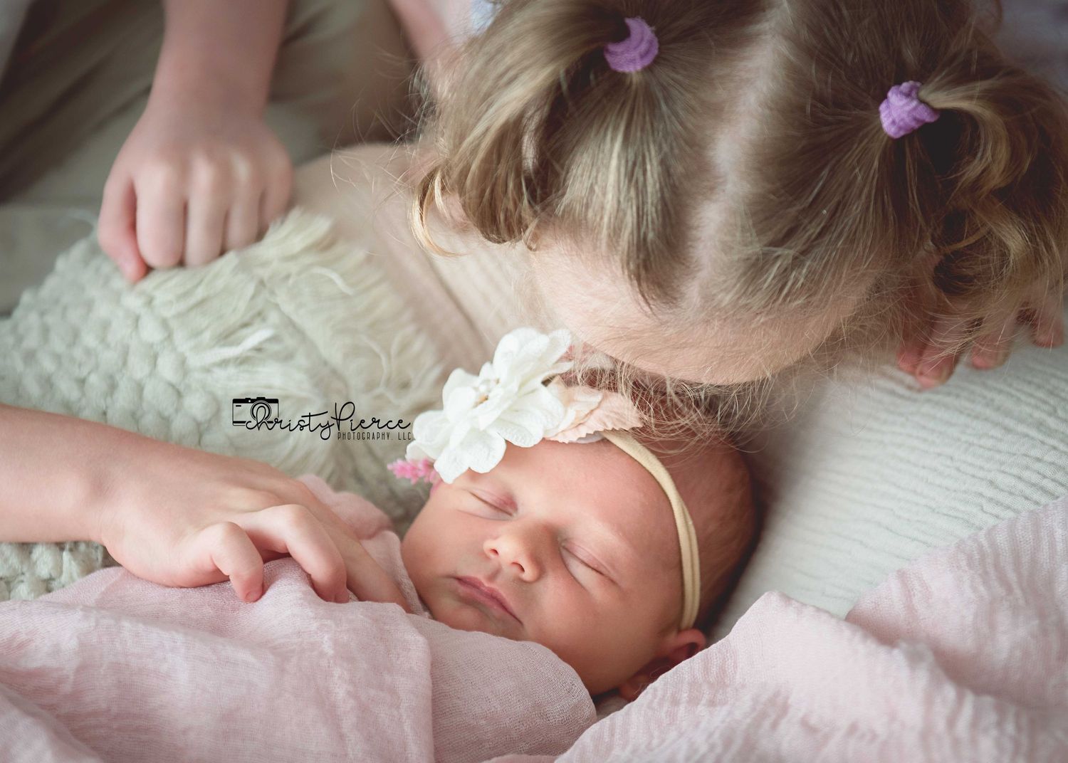 Sleeping baby with purple butterfly hair clip lying on white bedding in a series of peaceful sleeping poses.