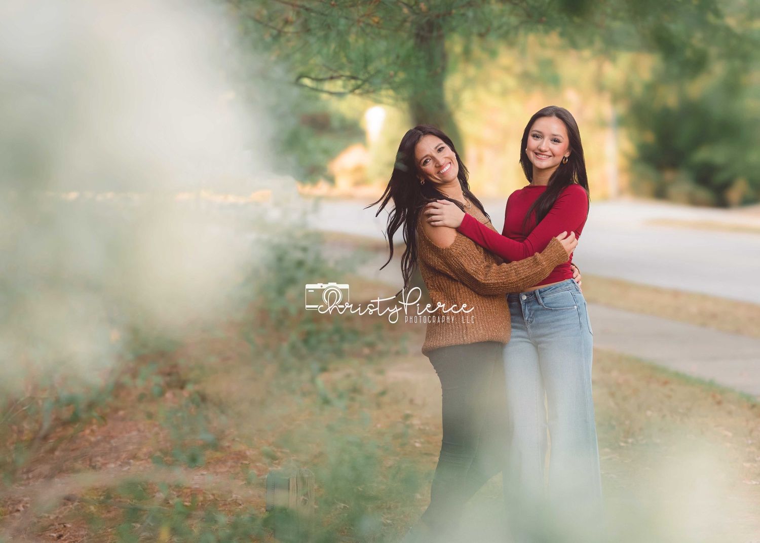 Two friends share a joyful moment together outdoors on a path with soft dreamy lighting and smoke effects.