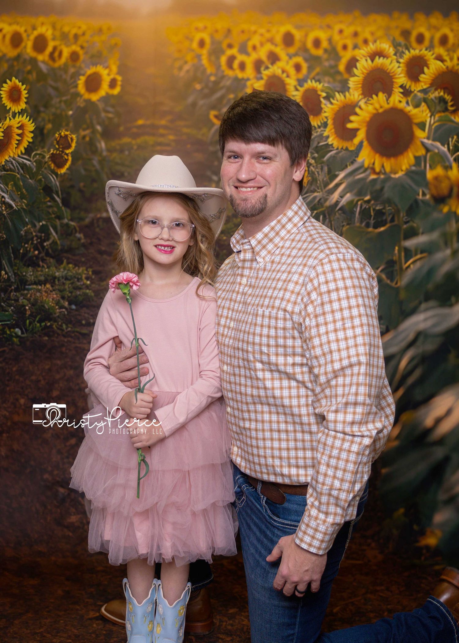 A heartwarming family portrait in a sunflower field at sunset with warm golden lighting and natural outdoor setting.