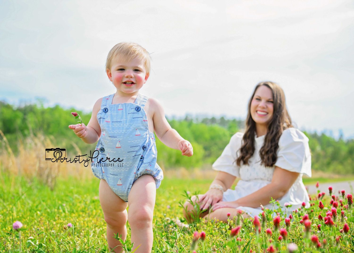 People enjoying a sunny day in a wildflower meadow with blooming pink flowers on a bright summer afternoon.