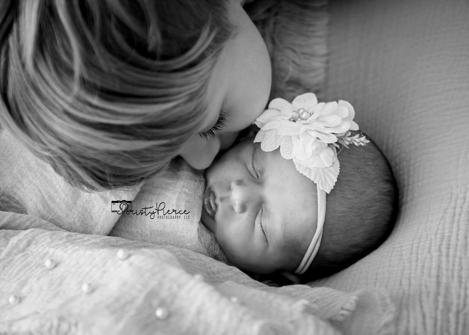 A black and white collage of sleeping babies wearing headbands and swaddles on soft bedding.