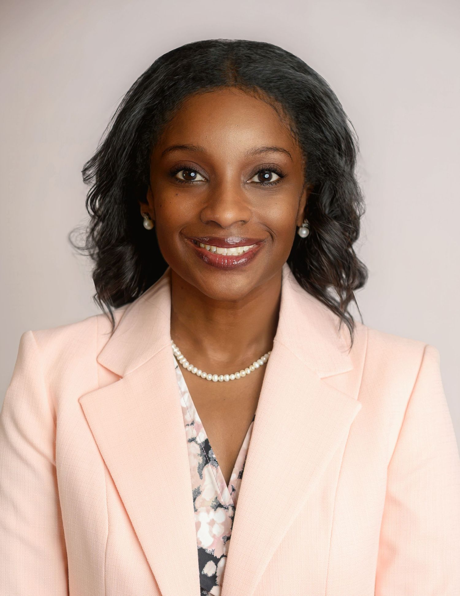 Professional portrait series in light pink blazer and floral top showing different poses against neutral background.