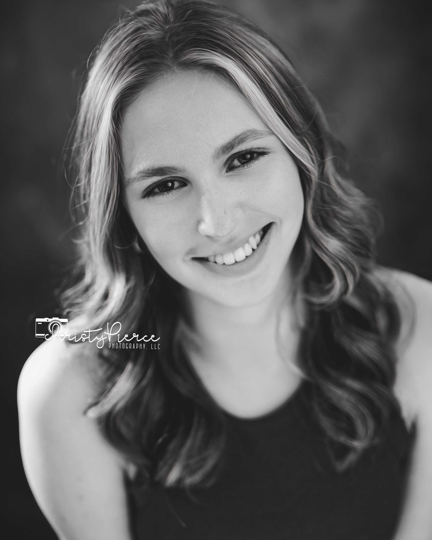 Black and white portrait series showing a smiling subject with wavy hair in different candid poses.