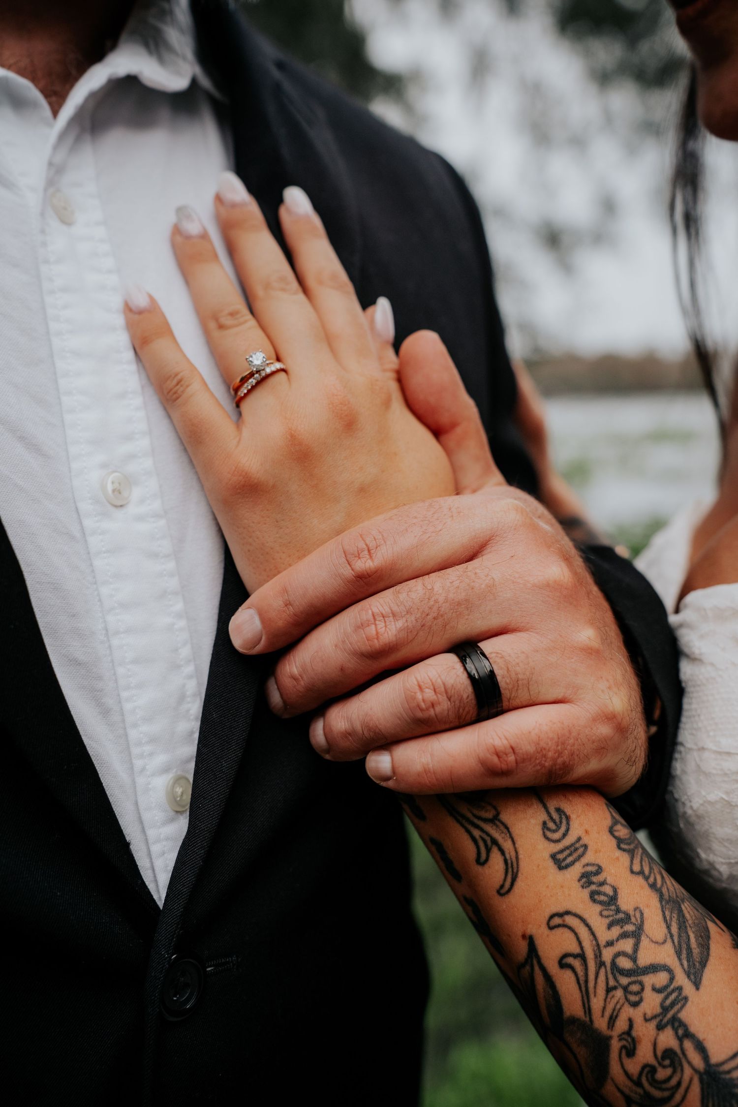Close-up series of hands showing wedding ring and intricate tribal tattoo sleeve against white shirt and black suit.