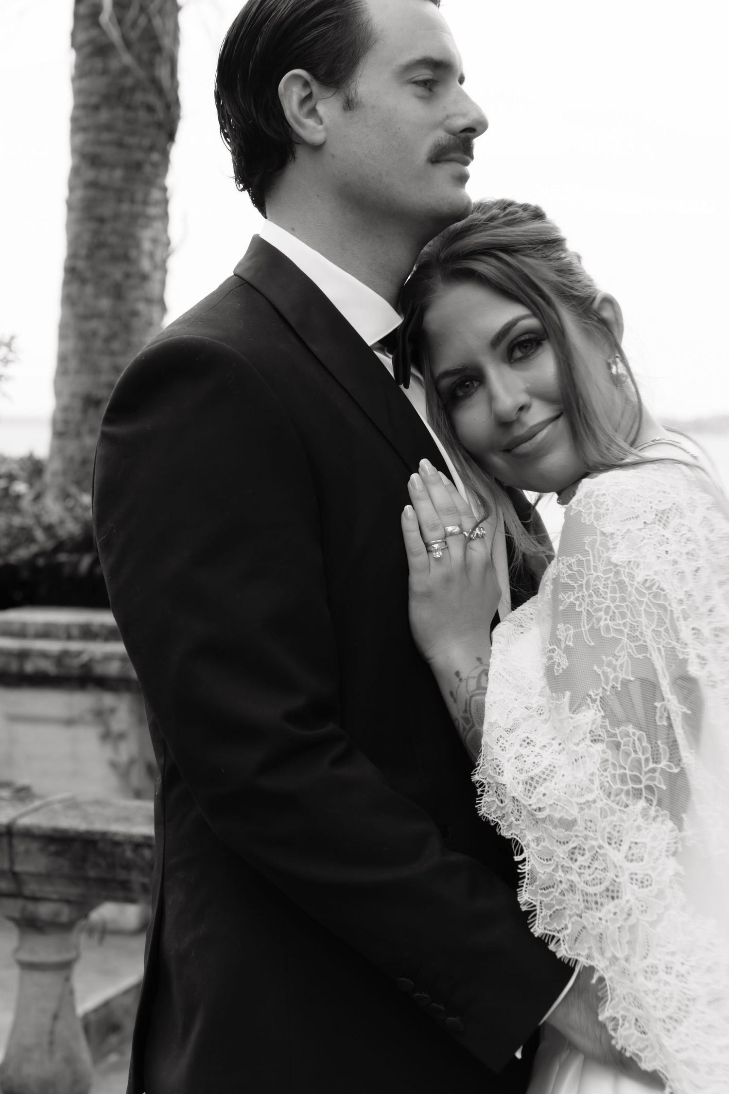 A romantic black and white wedding photo series showing tender moments between a couple in formal attire.