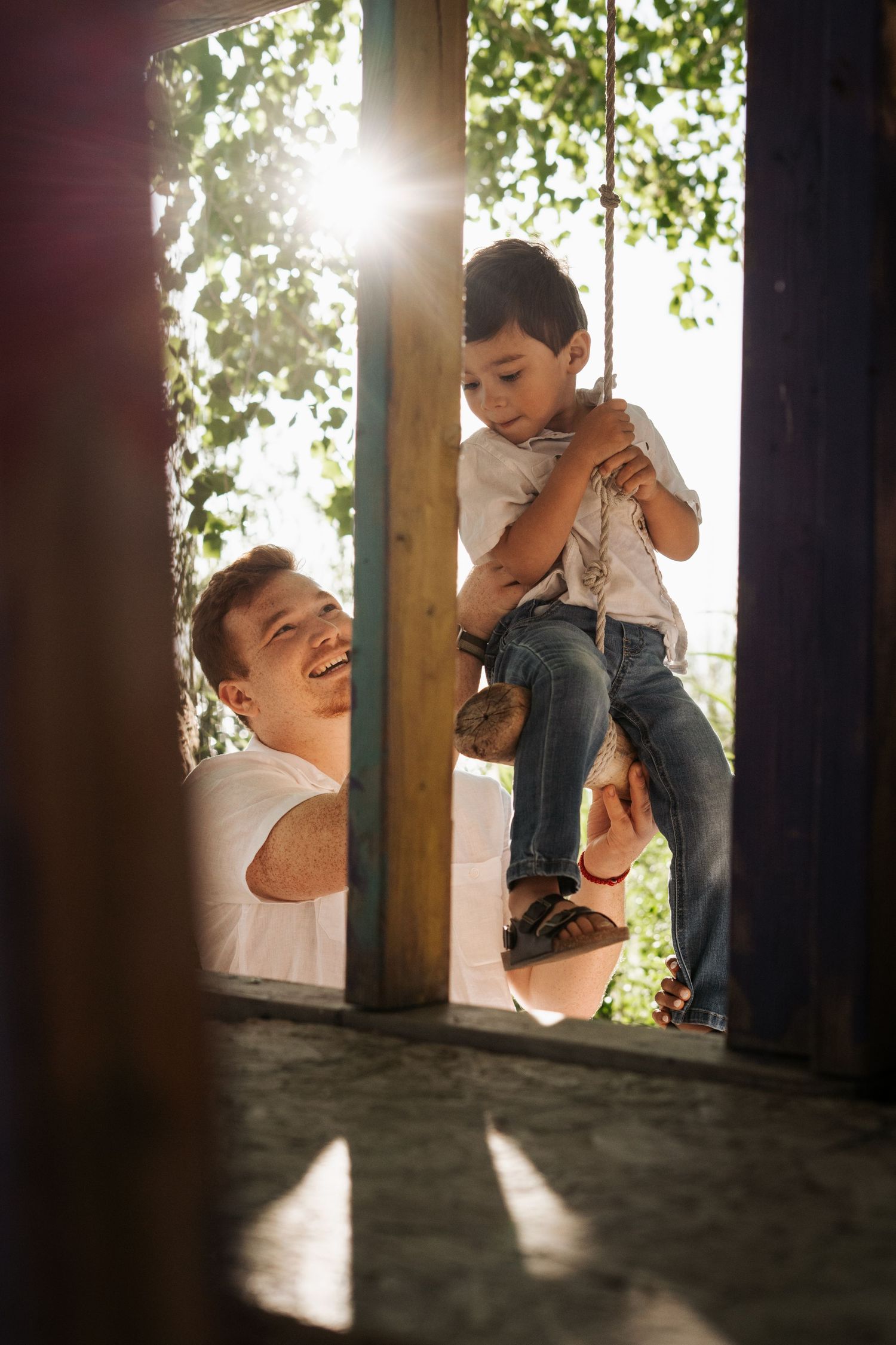 A playful sequence shows a parent and child sharing joyful moments while climbing on wooden beams in sunlit surroundings.