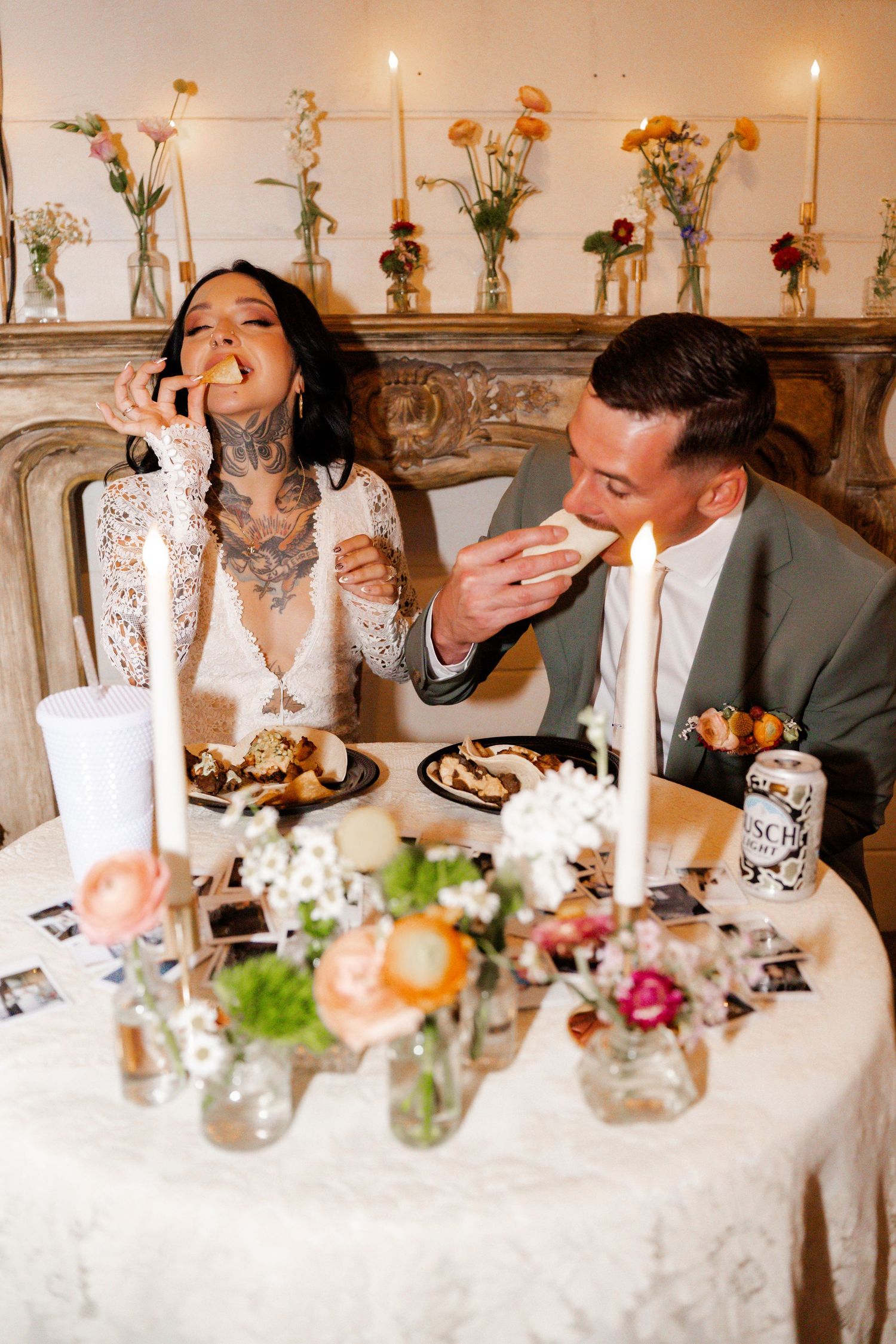 A couple enjoys desserts at an intimate dinner table decorated with candles and floral arrangements.