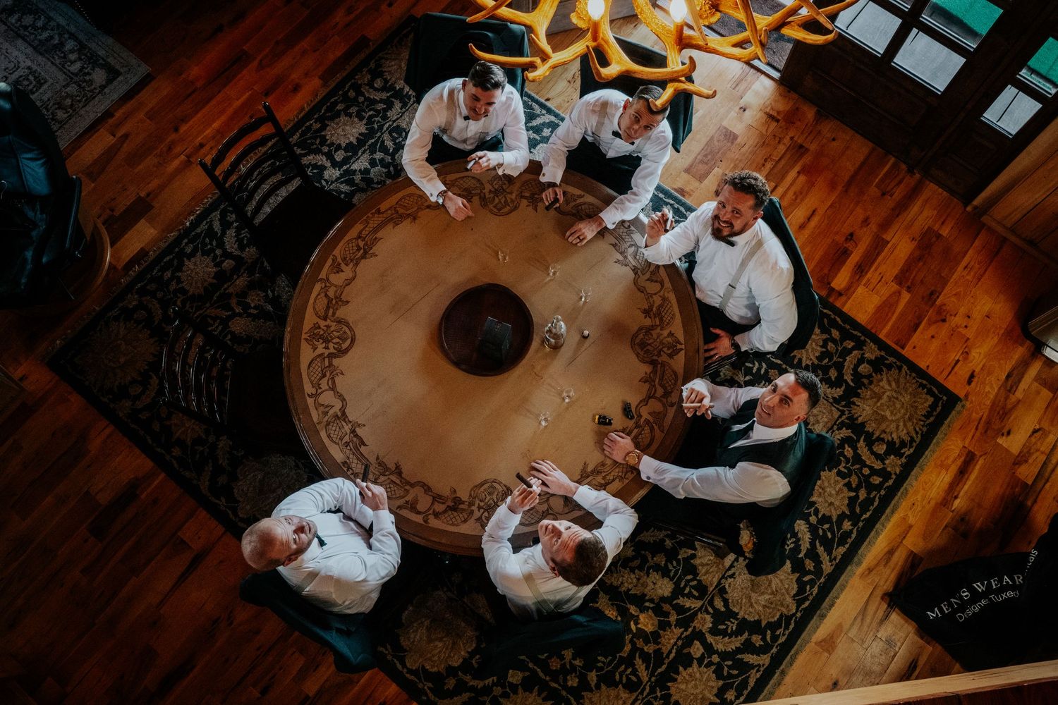 A couple dances together during their first dance at a wedding reception with warm lighting and a patterned floor.