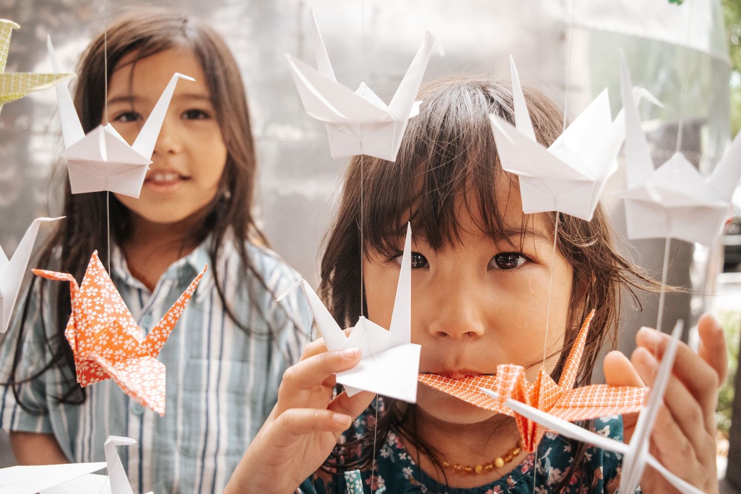 Paper origami crown decorations being displayed against a window.