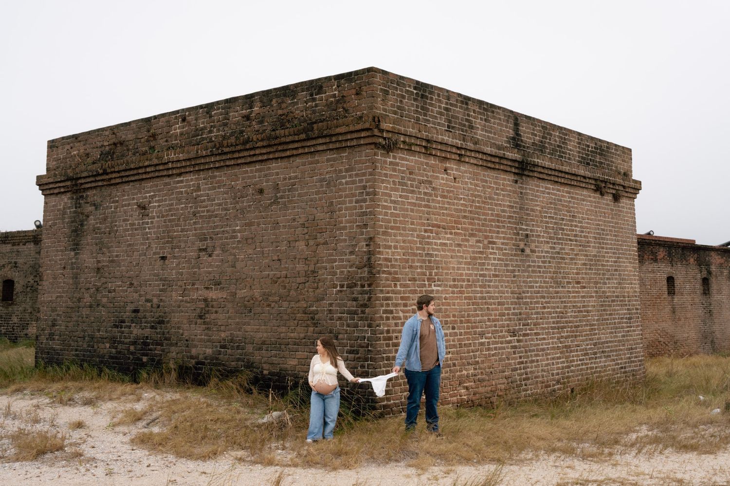 Historic brick fortification walls stretch along the coastline showing weathered textures and architectural details.