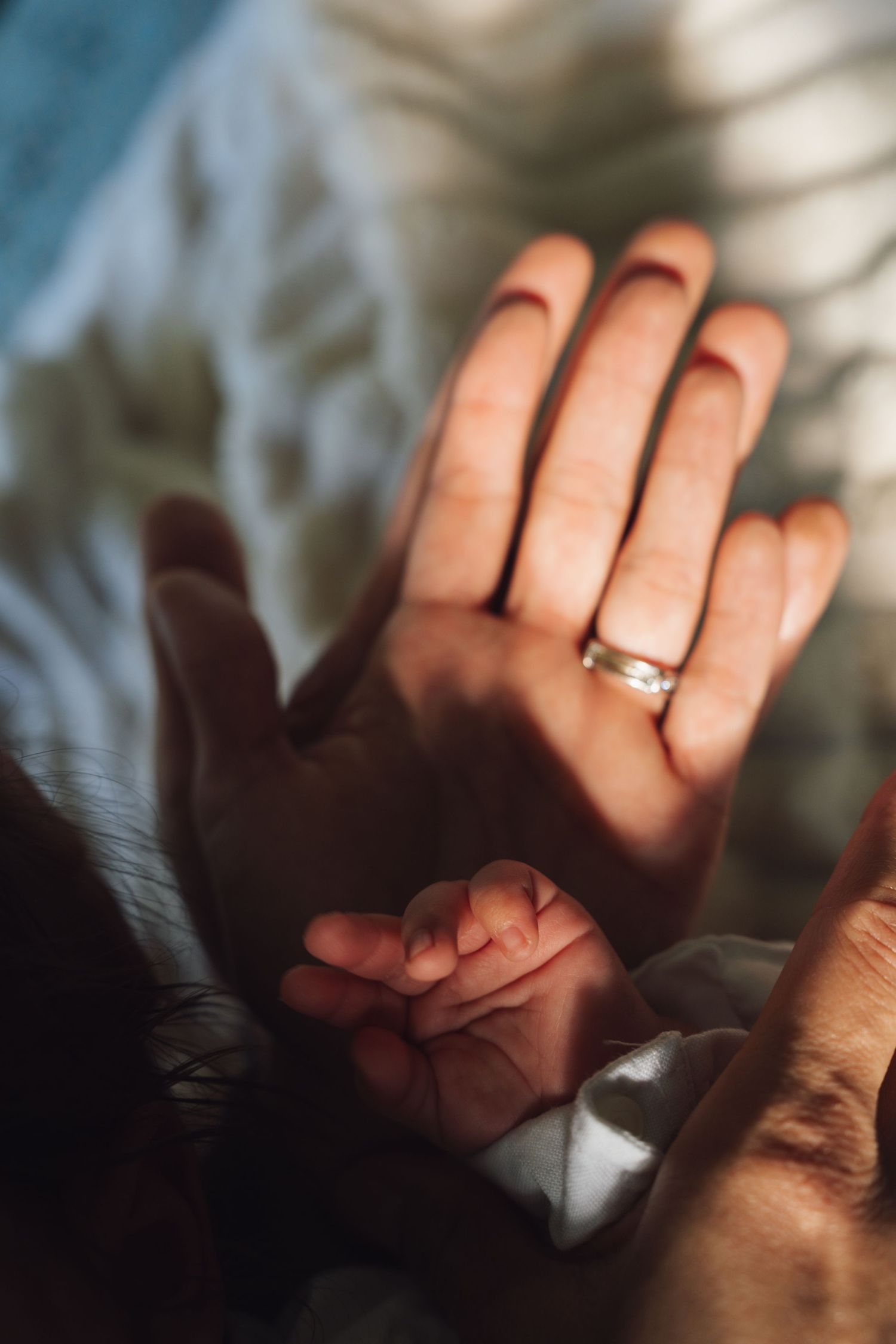 Close-up shots of hands with an engagement ring casting delicate shadows in sunlight.
