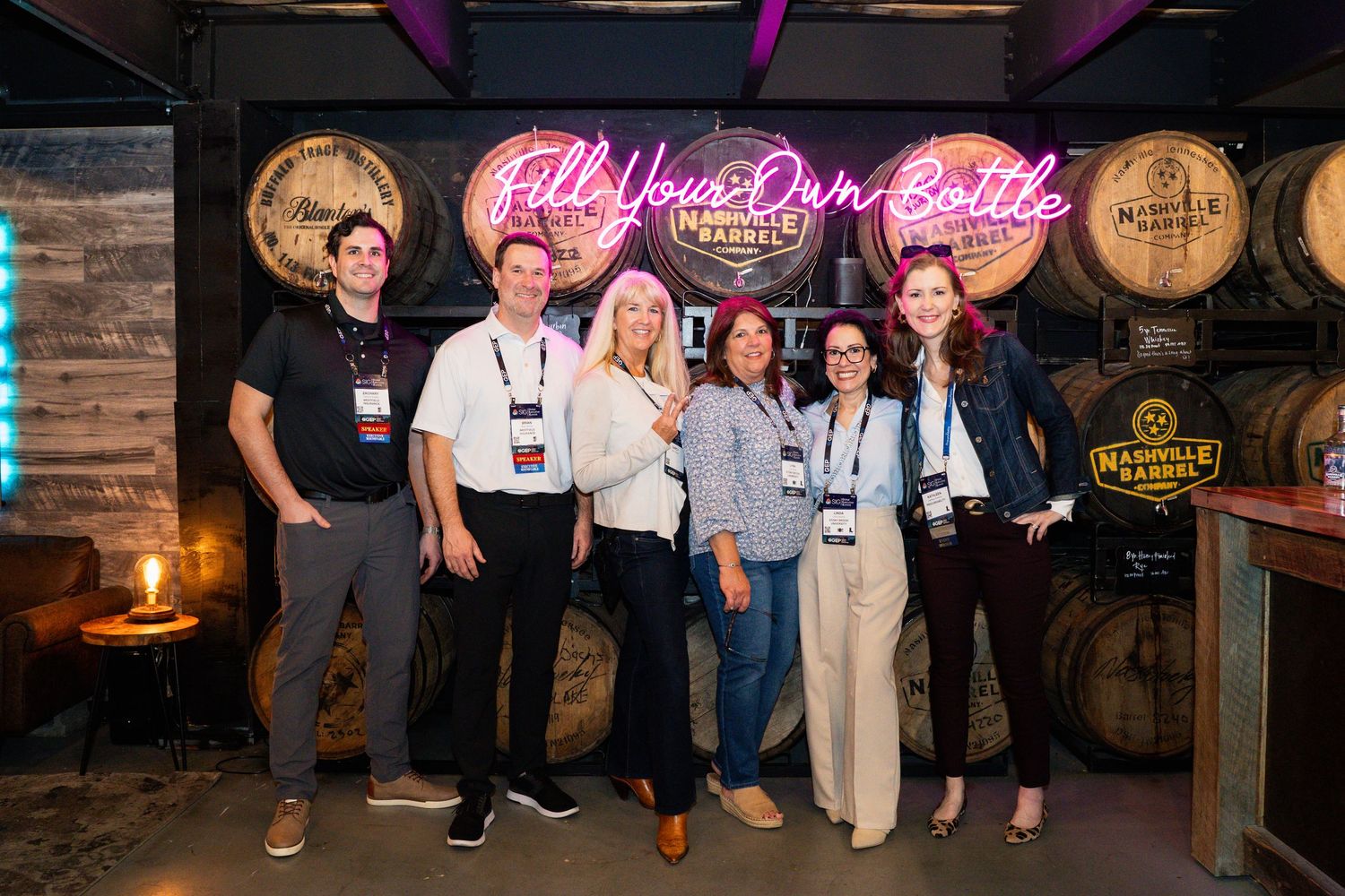 Group of six people posing together at a Nashville barrel distillery Fill Your Own Bottle experience event.