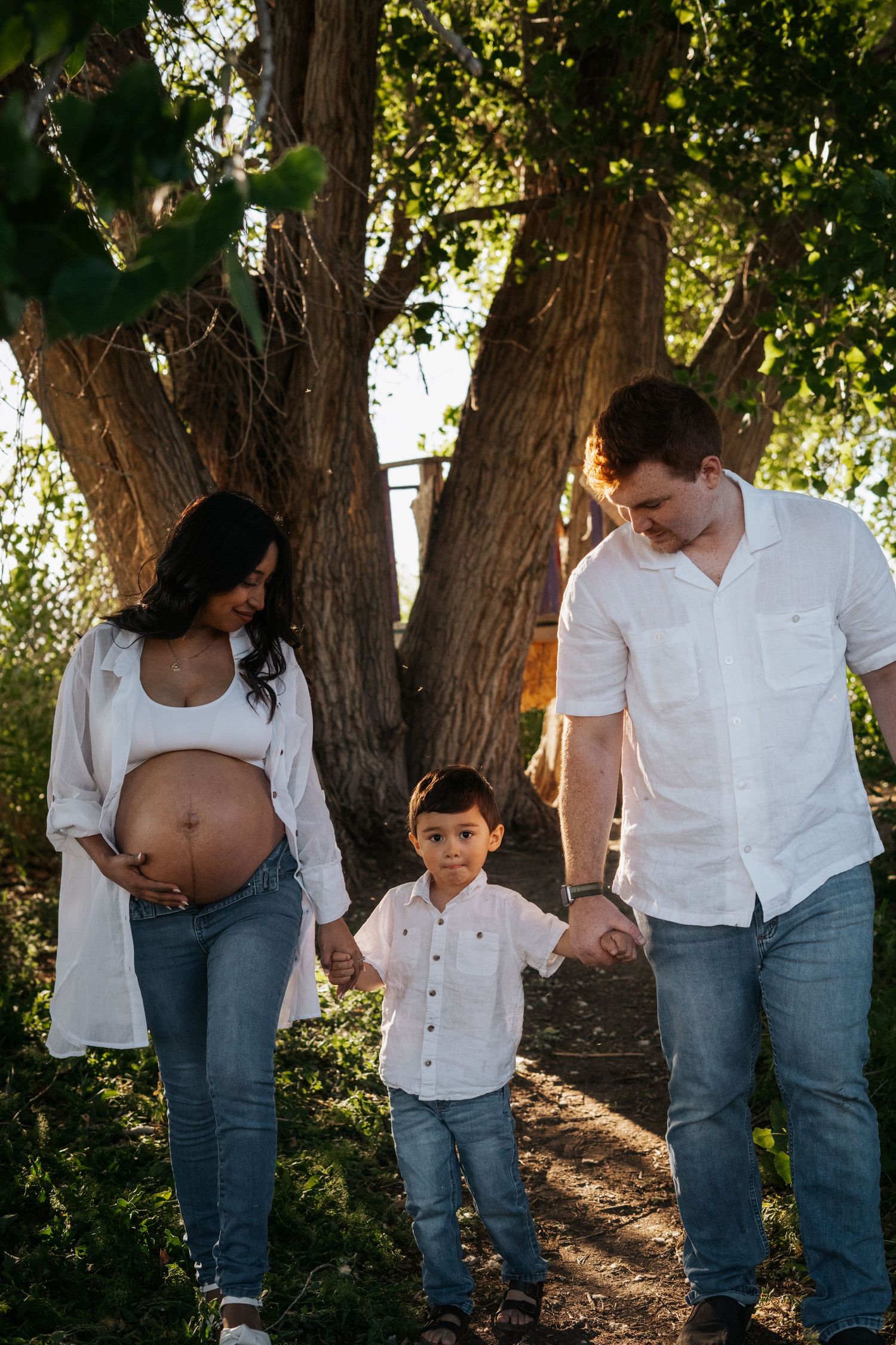 A series of candid family photos showing tender moments between parent and child in a sunlit wooded setting.