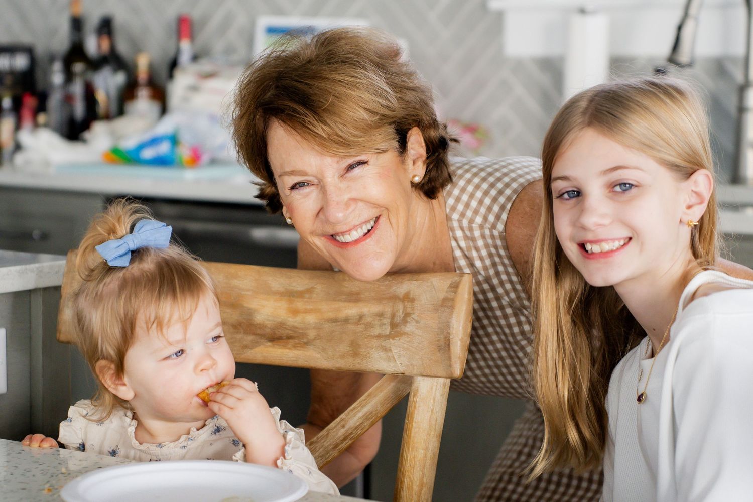 Three people share a joyful moment together in a kitchen setting.