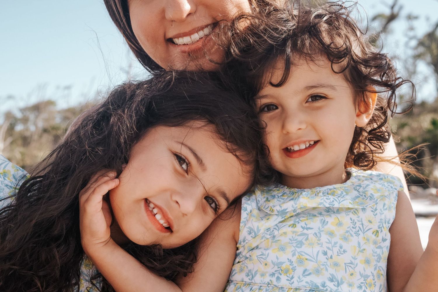 Close-up of two young members of a family sharing a joyful moment outdoors.