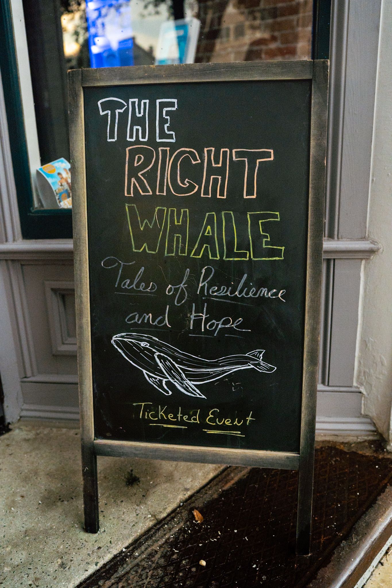 Chalkboard sign for The Right Whale event, Tales of Resilience and Hope, a ticketed event with whale illustration.