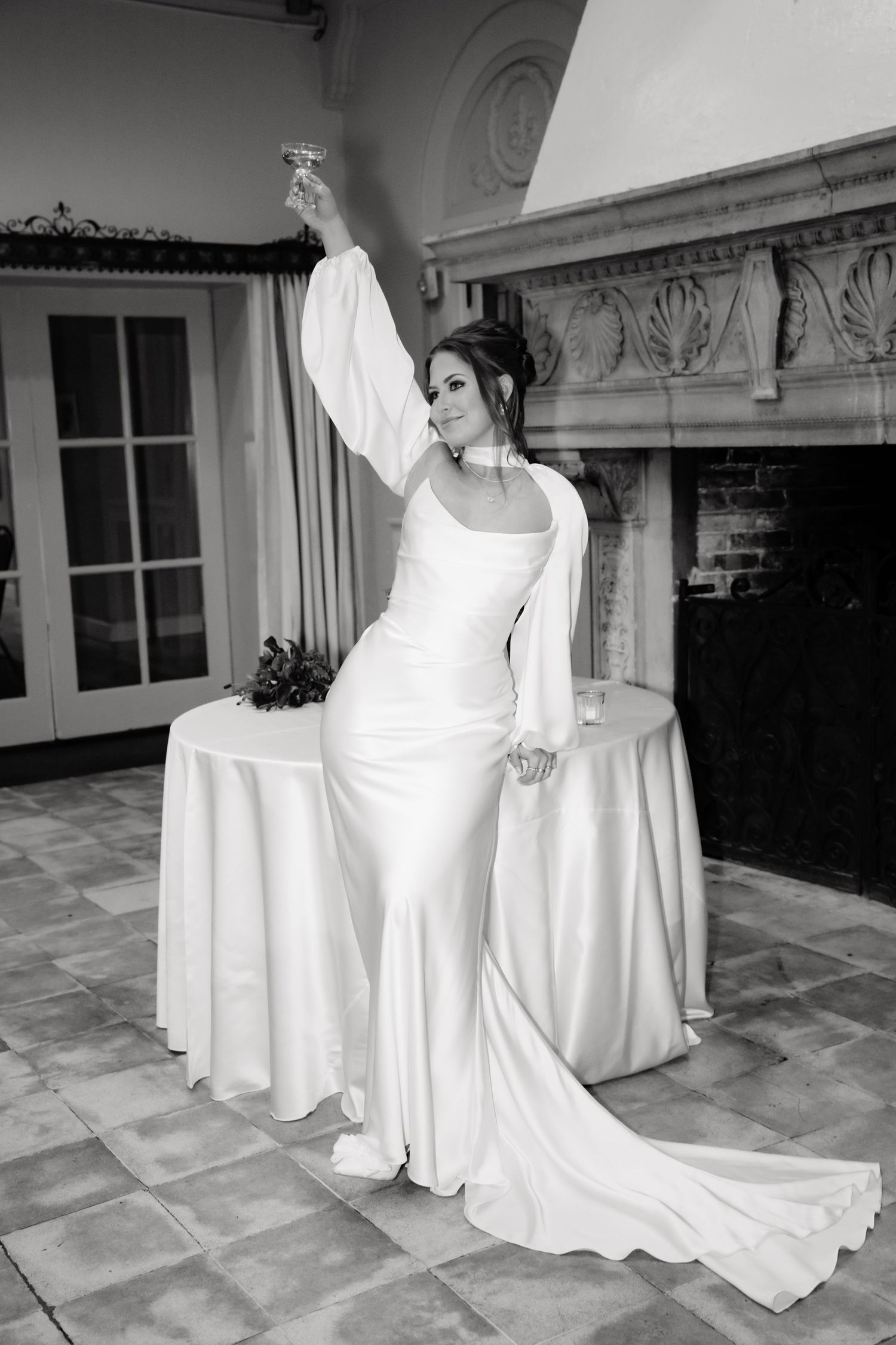 A series of black and white photos showing people in flowing white wedding dresses gathered on a stone patio.